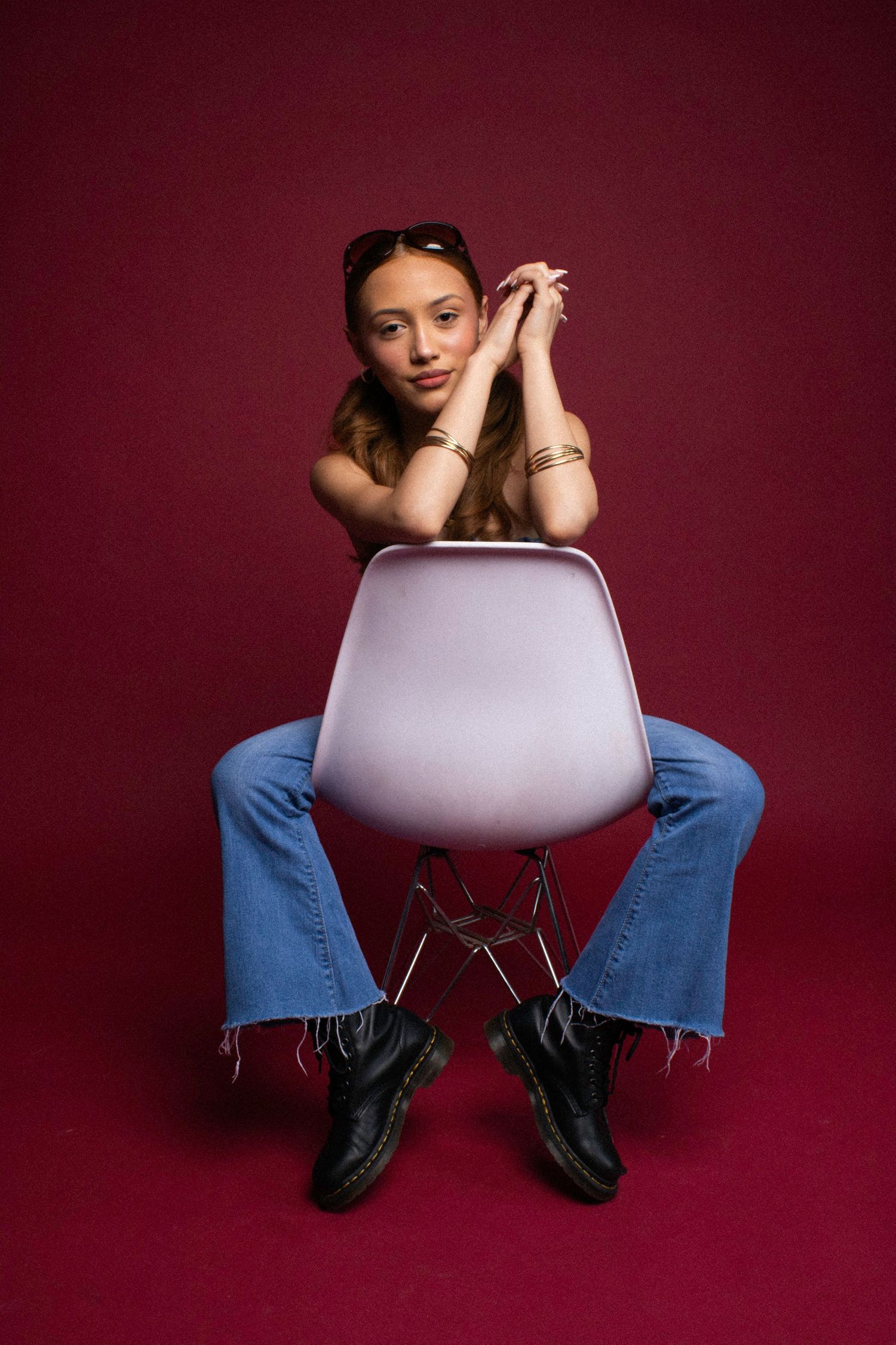 Modern chair against burgundy backdrop in studio setting.