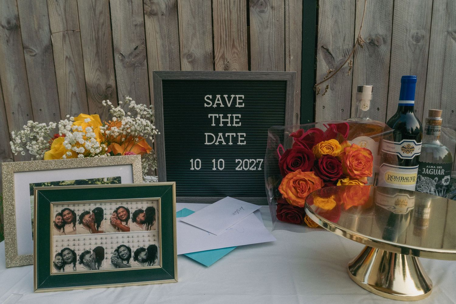 Wedding decorations including rustic wooden backdrop with floral arrangements and signage.