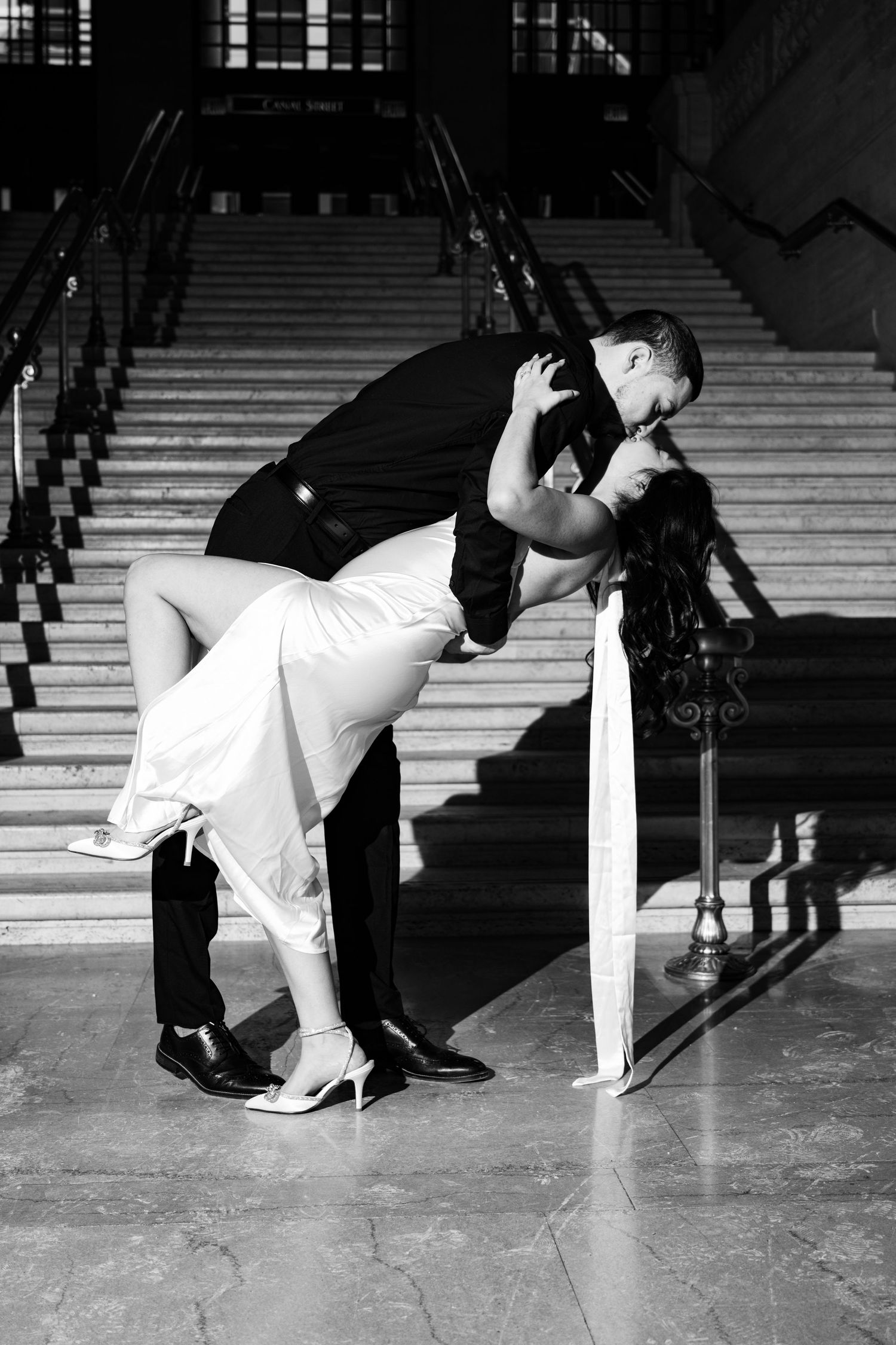 Dramatic black and white dance sequence showing couple dipping on stairs.