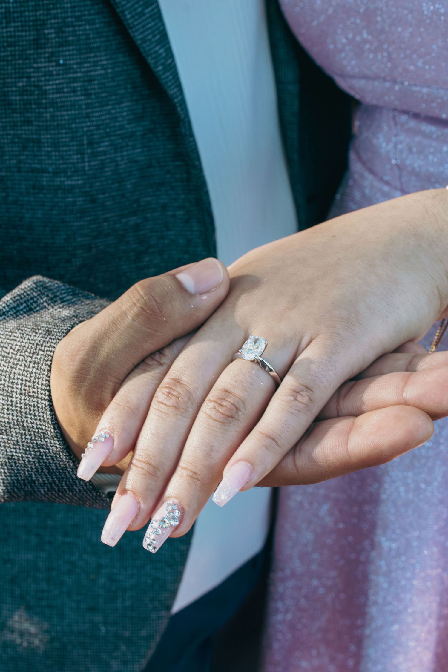 Close-up shots of hands with engagement ring and manicured nails against dark background.