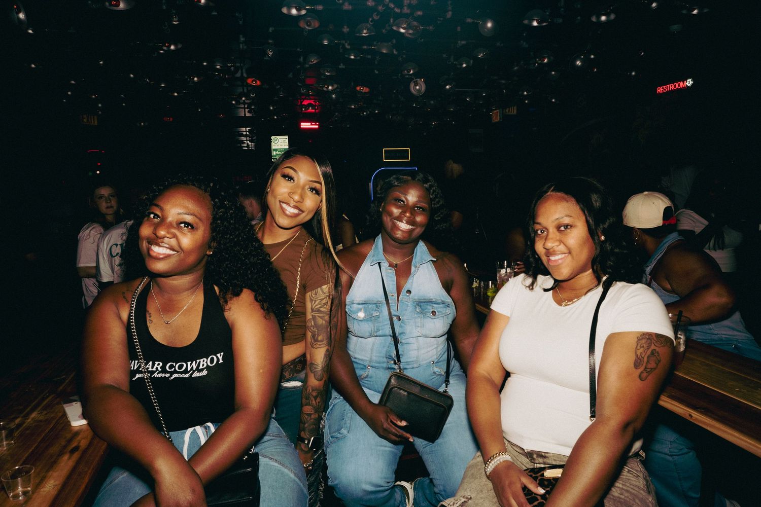 Group enjoying themselves at a dimly lit nightclub event.