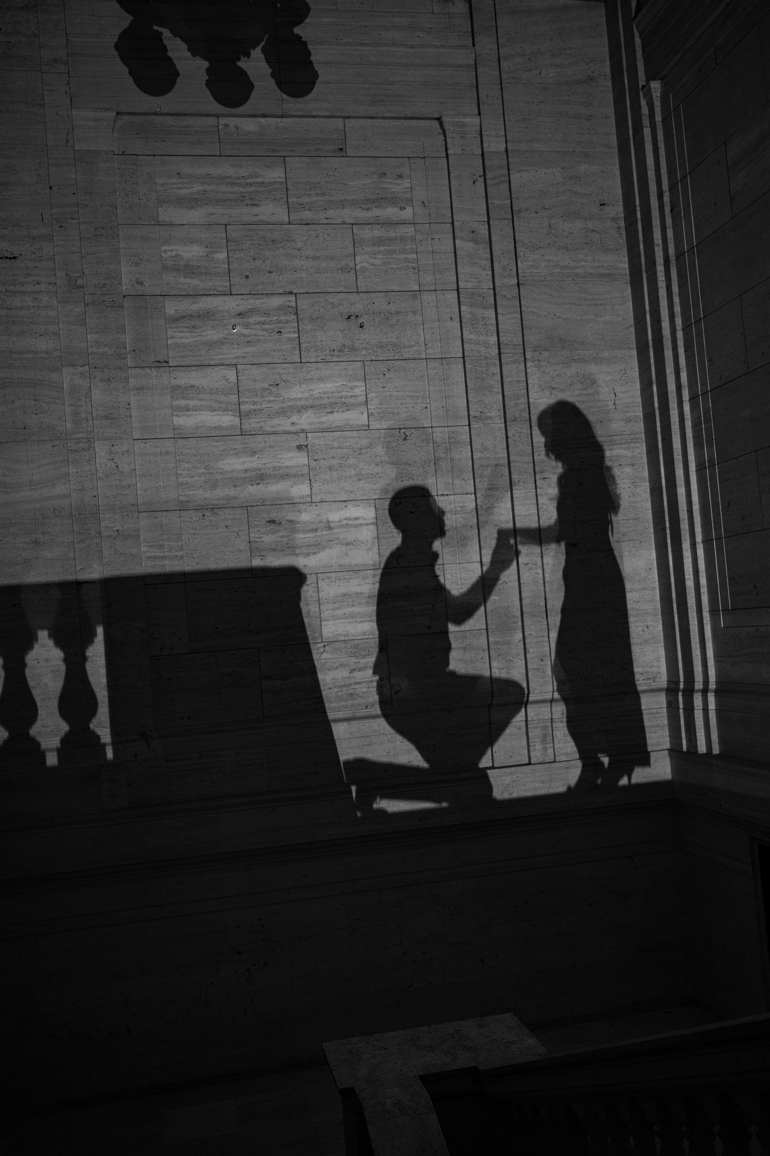 Silhouettes of people against a dimly lit wall creating dramatic shadows.