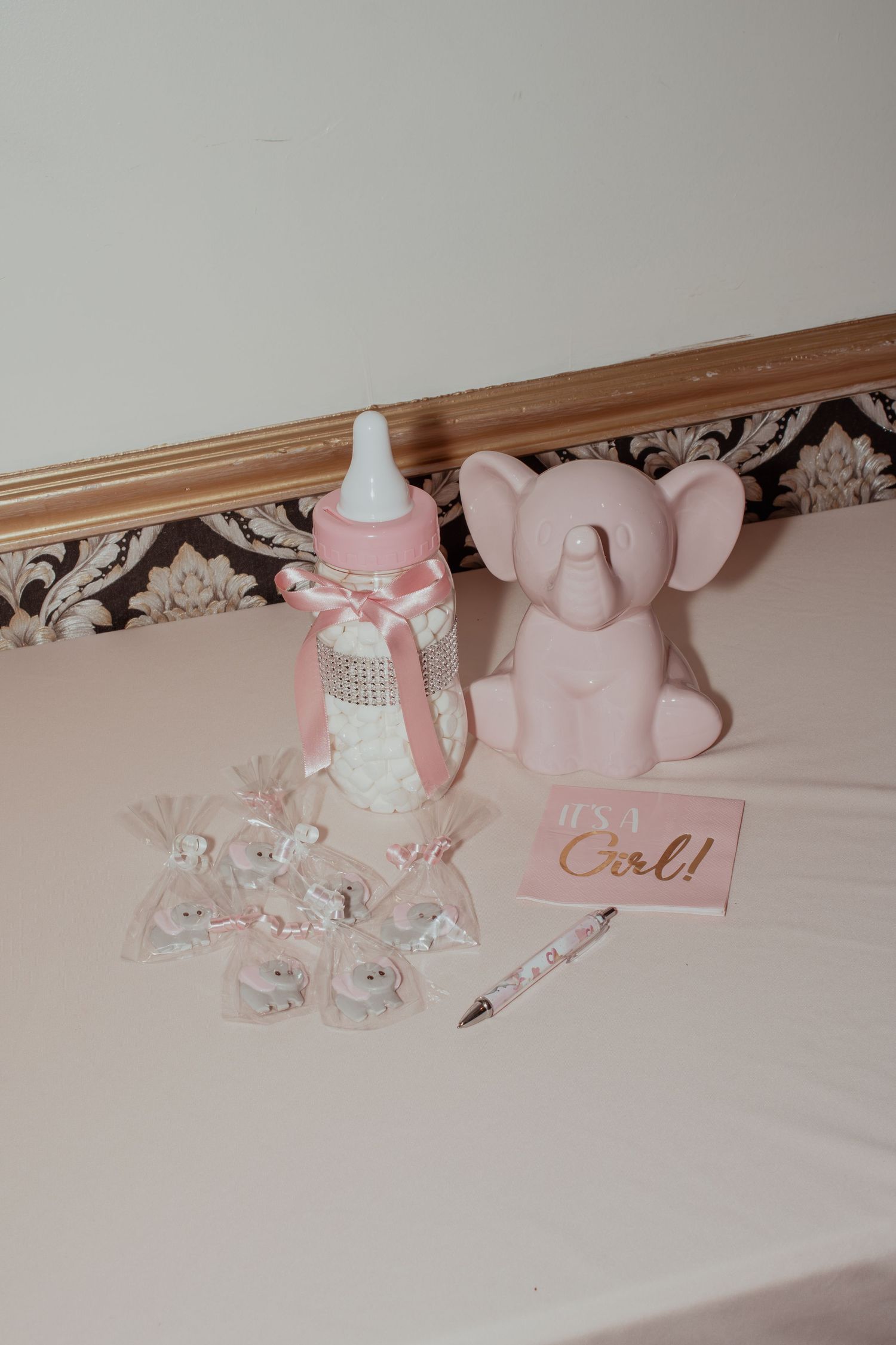 Close-up of pink and silver party decorations along a baseboard.