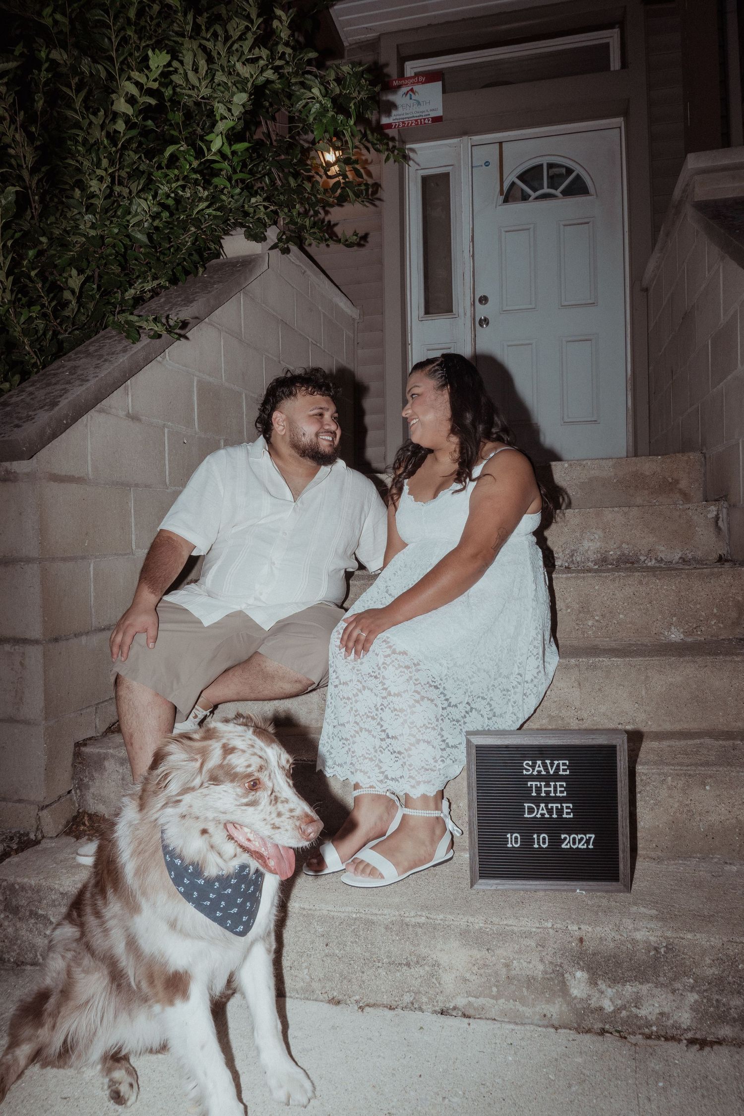 Romantic engagement photo on porch steps with dog and letterboard save the date sign.