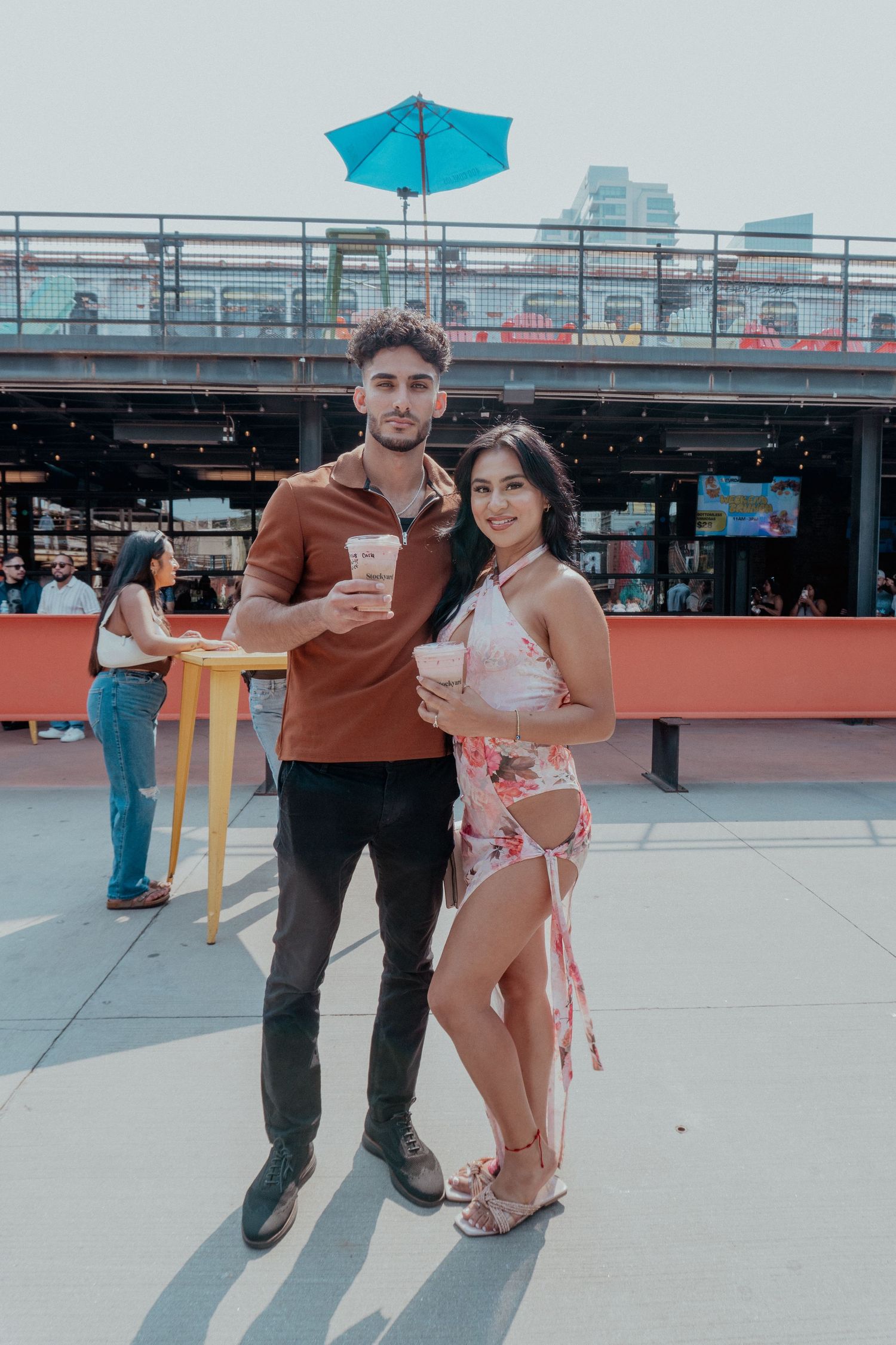 Couple enjoying drinks at outdoor rooftop venue.