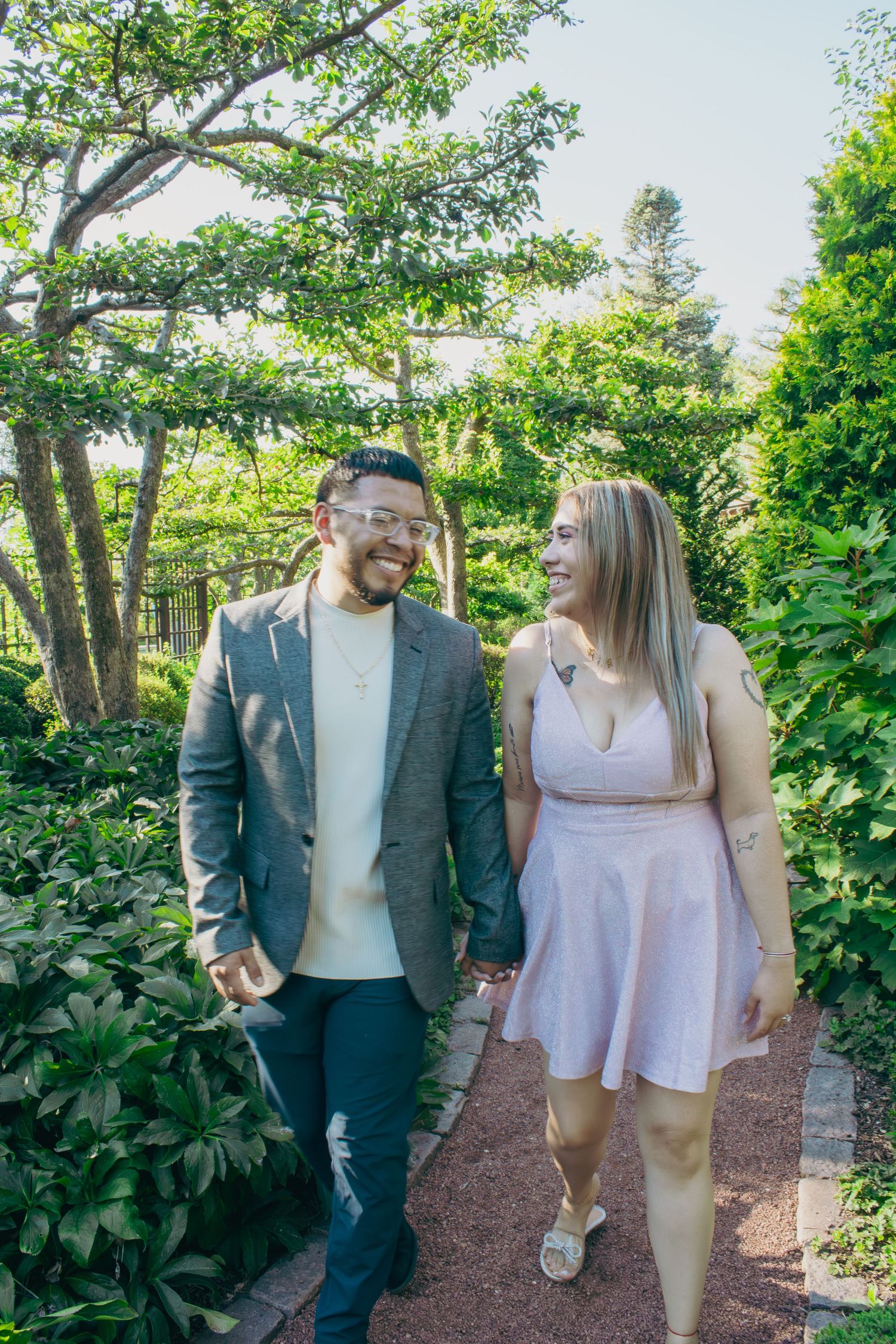 Couple strolling and laughing together on a mulch path in a garden setting.