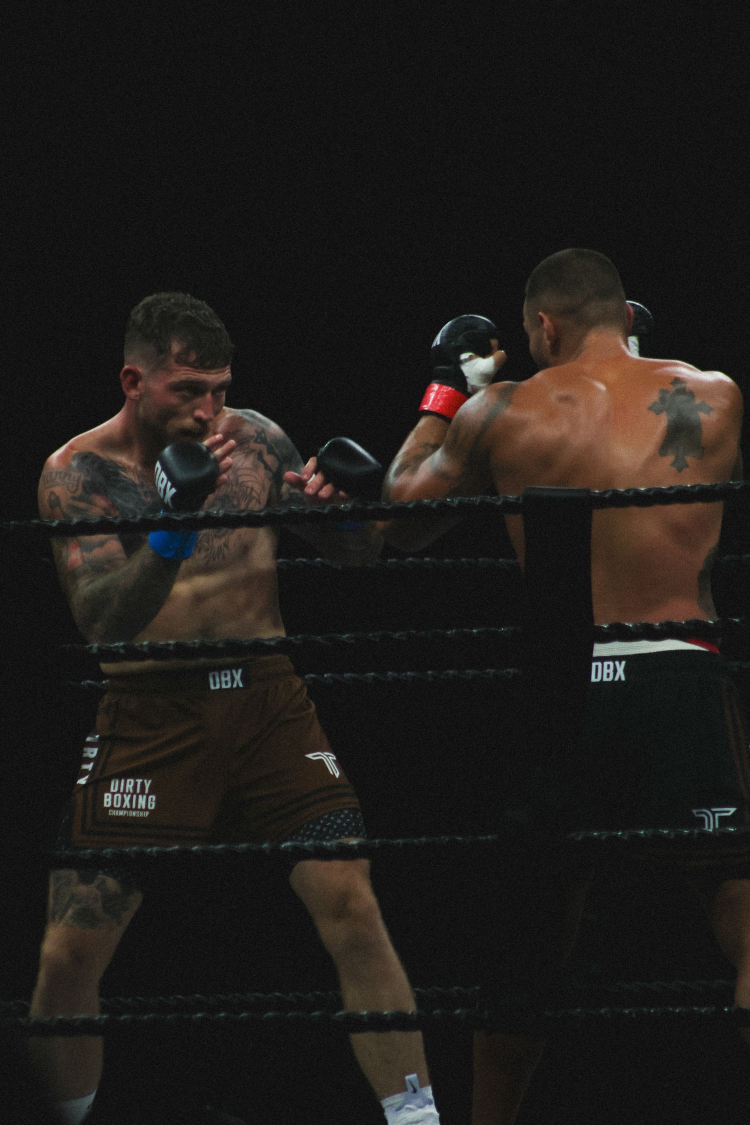 Boxers trade powerful strikes while competing in a professional boxing match.