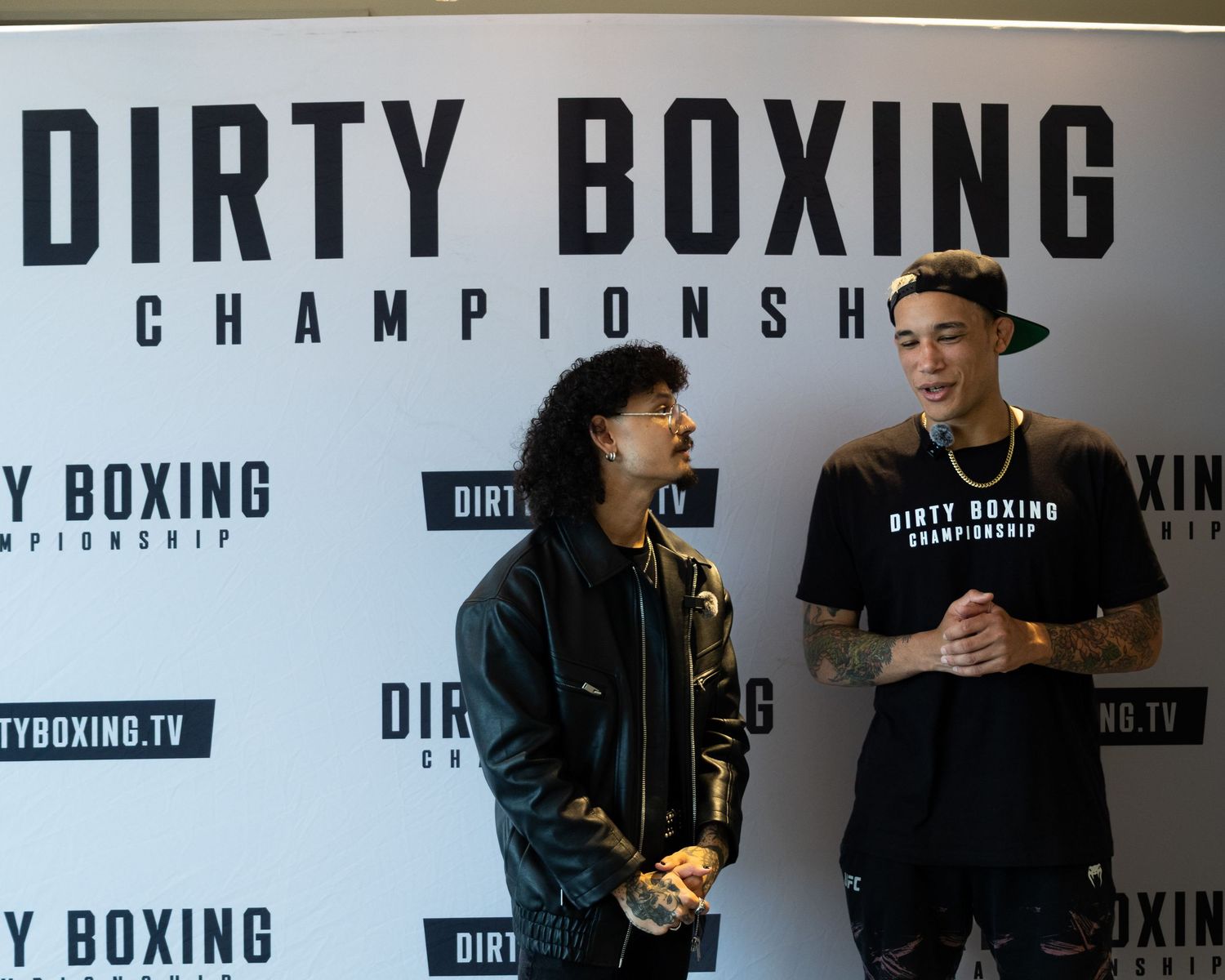 Wide shot of boxing championship branding wall with event signage.