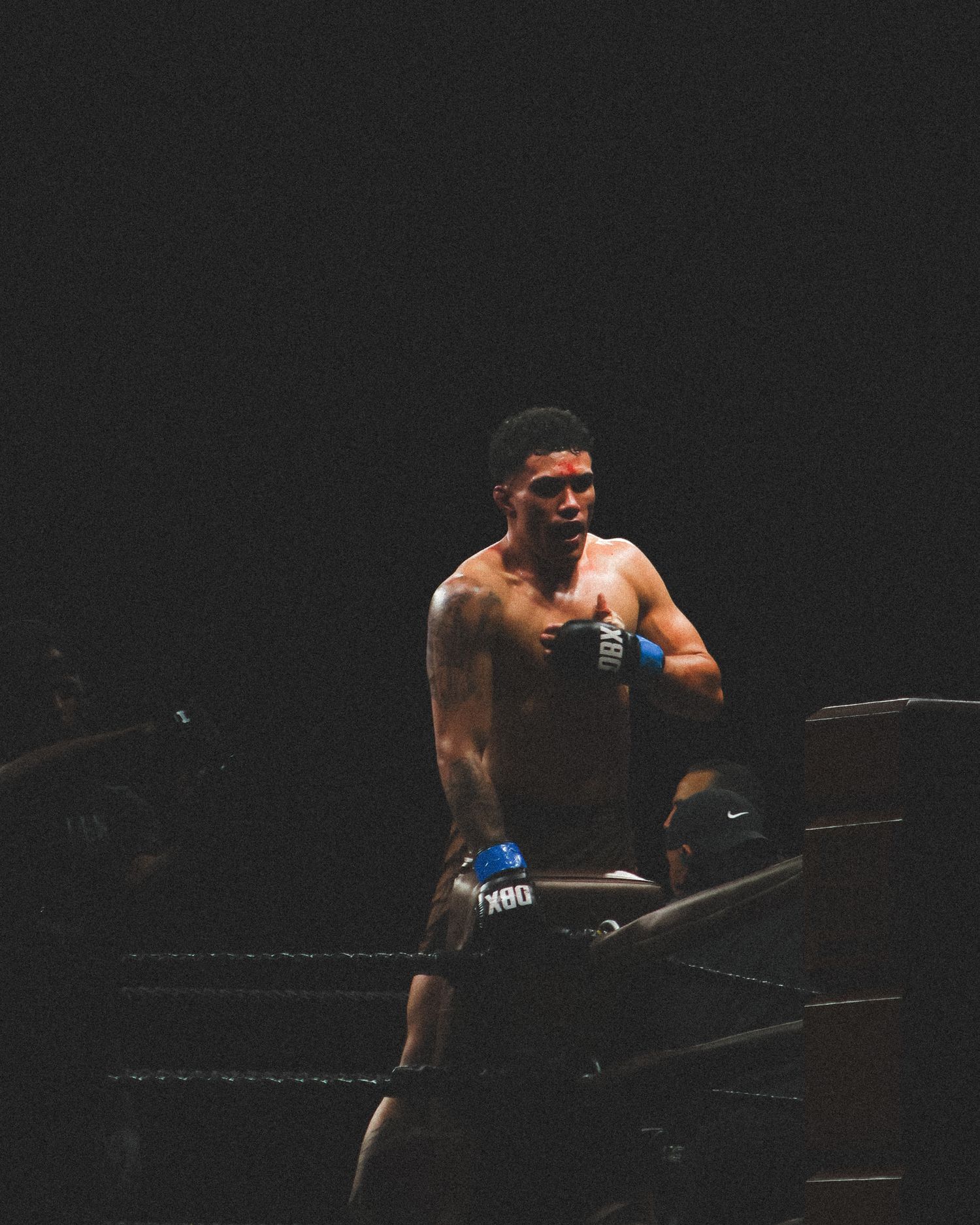 Two competitors face off in a dramatic moment during a boxing match.