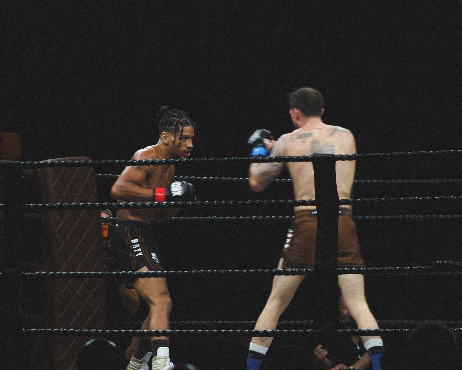 Boxers trade punches while circling each other in a professional match.