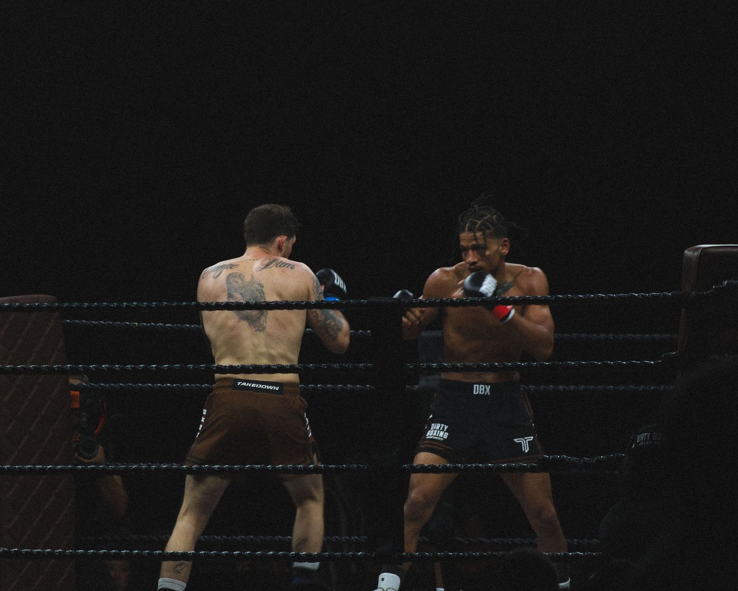 Two fighters exchange blows in a boxing ring during an intense bout.