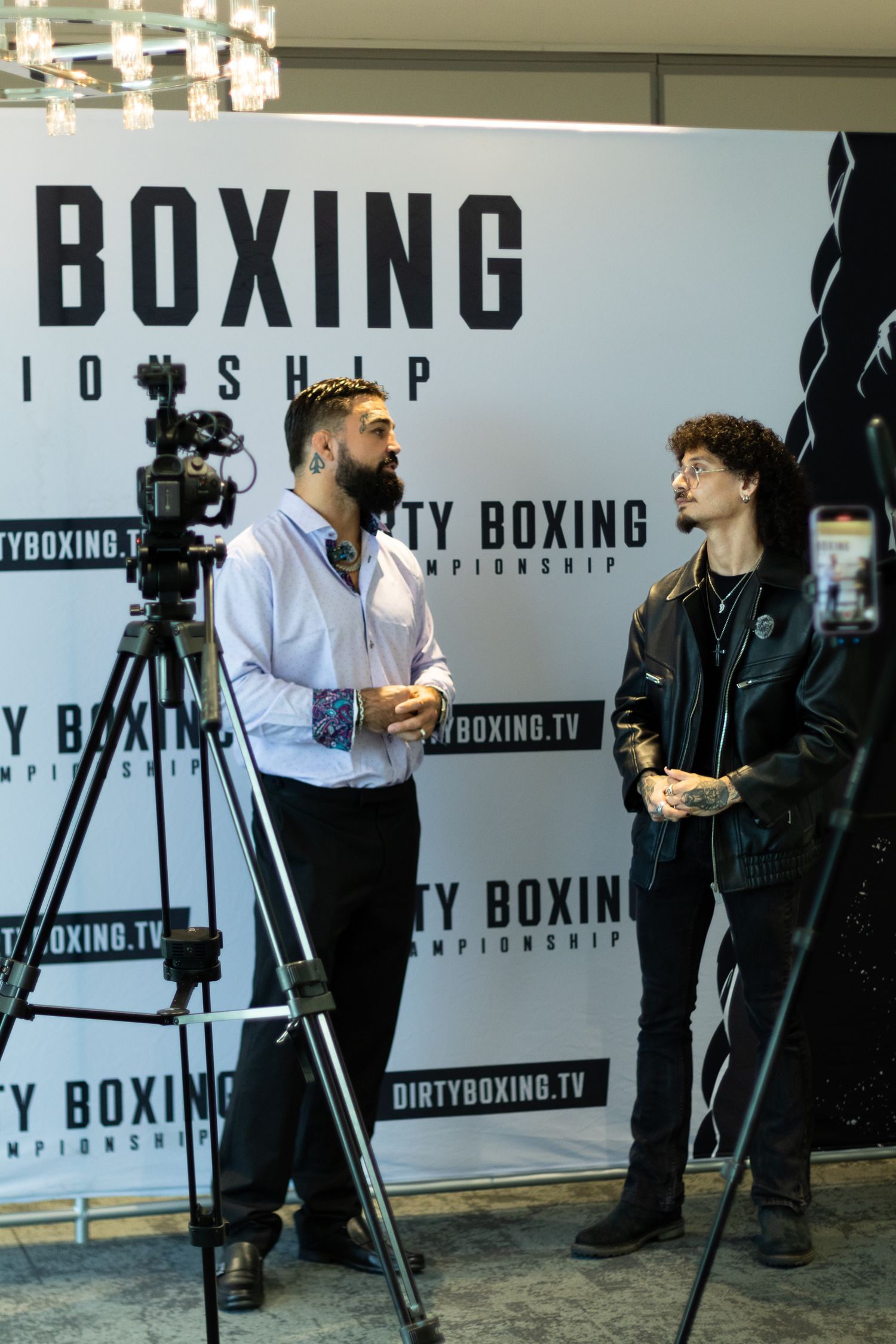Media interview session taking place in front of Dirty Boxing promotional backdrop.