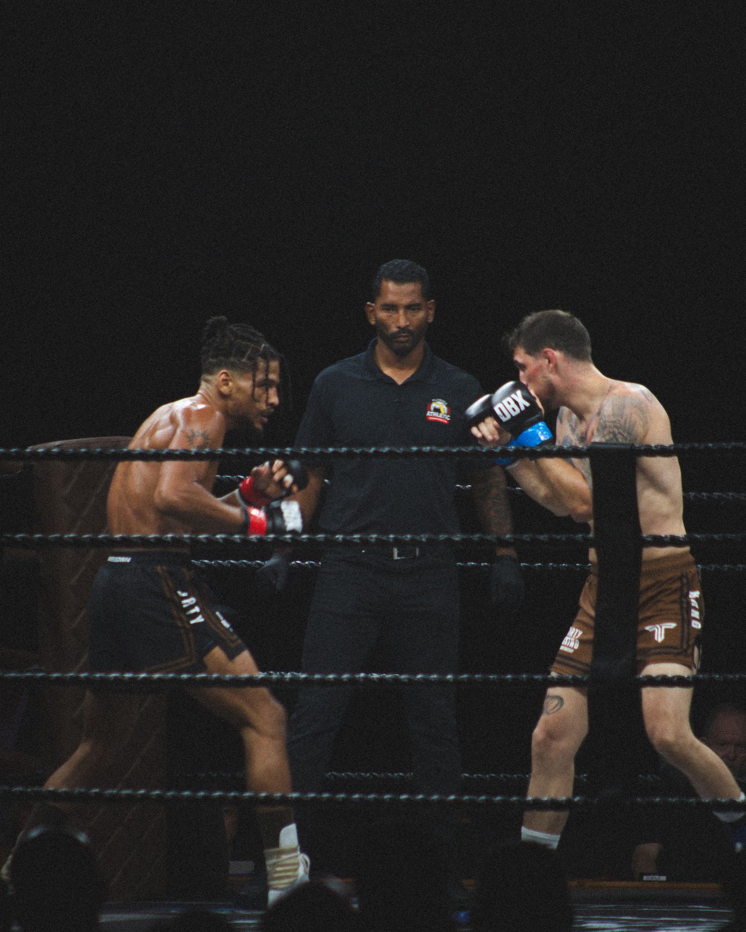 Two athletes demonstrate their boxing skills during an intense match.