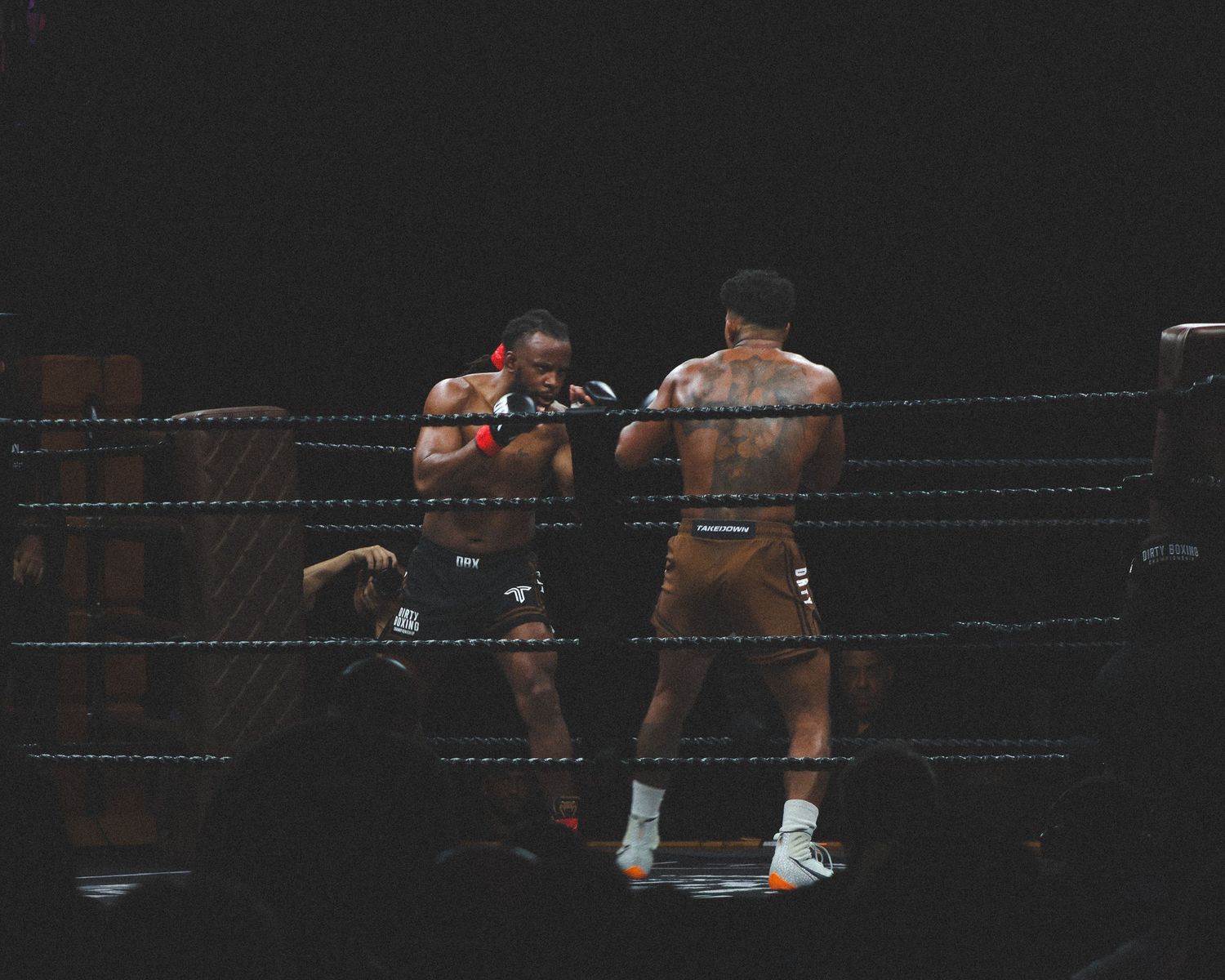 Two boxers exchange blows during an intense professional boxing match.