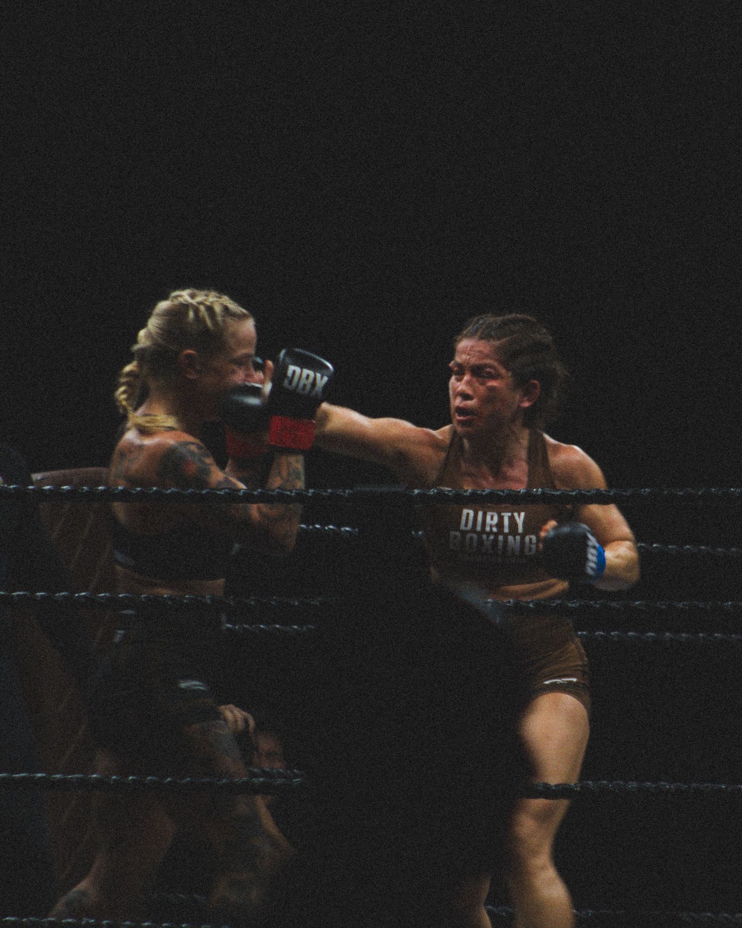 Boxers trade punches during an intense exchange in the ring.