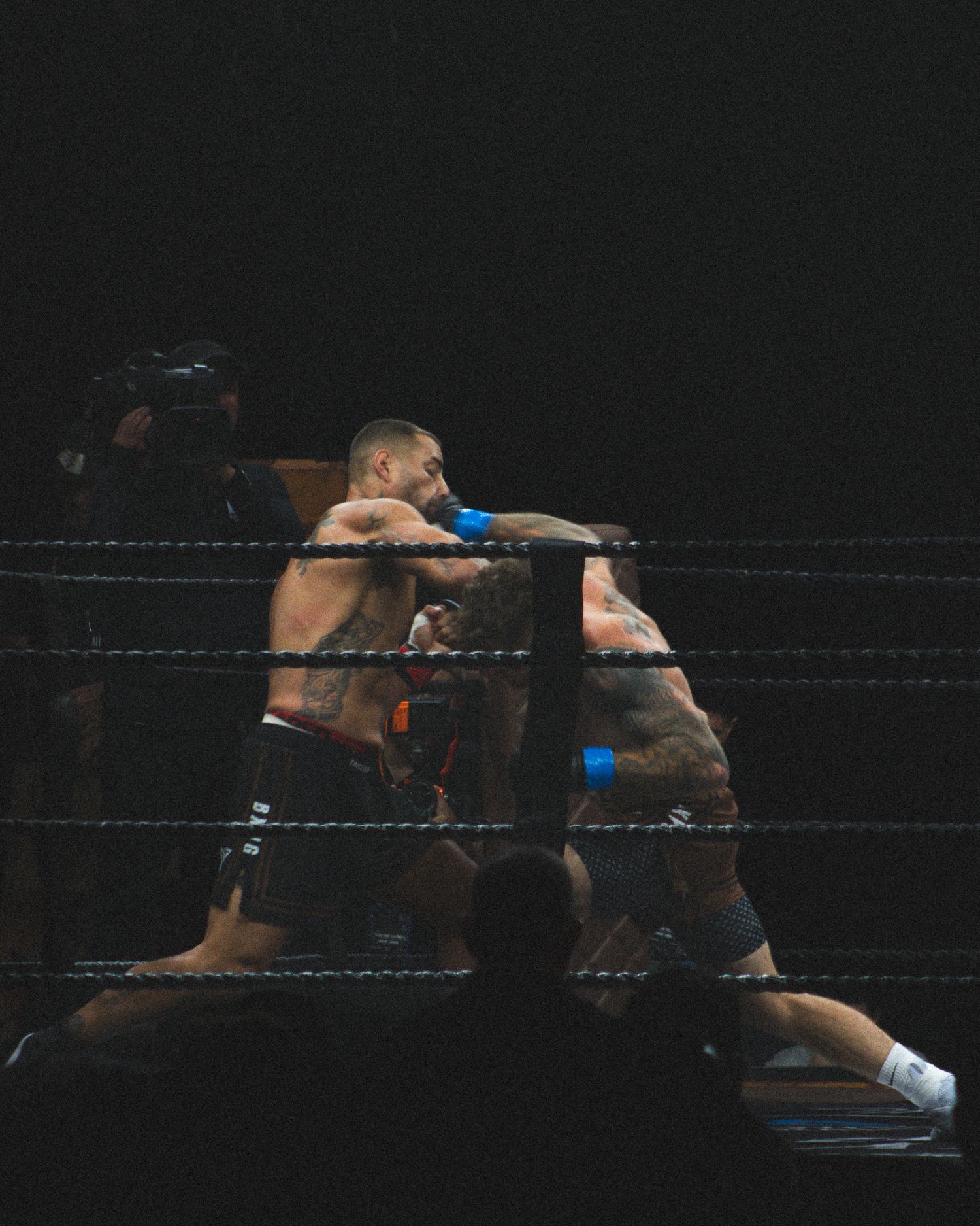 Two athletes engage in close-quarters combat during a boxing match.