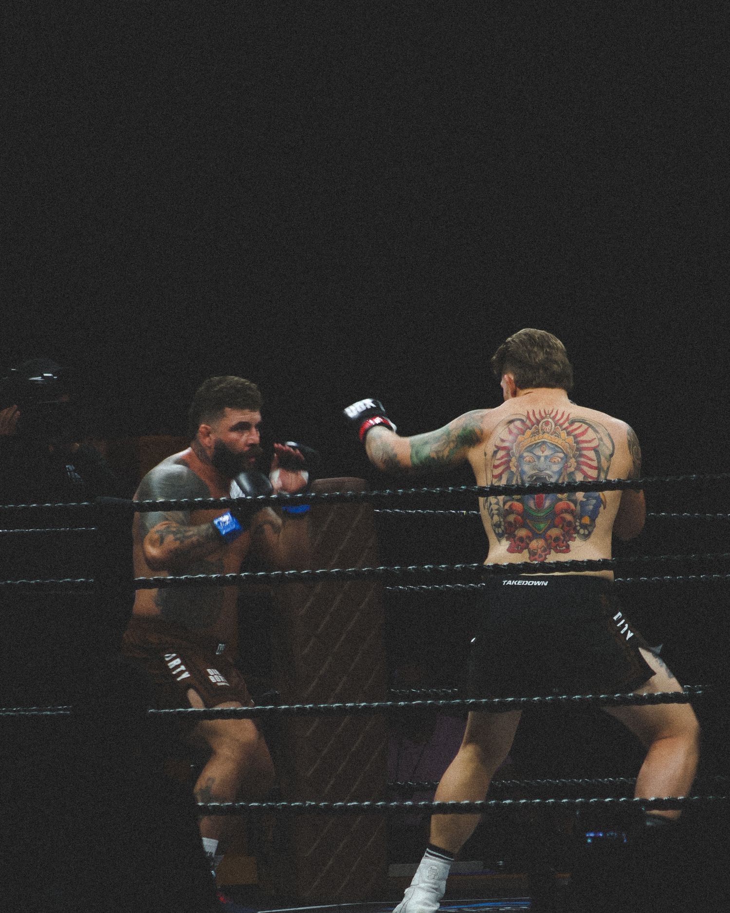 Two fighters exchange blows in close combat during a boxing match.