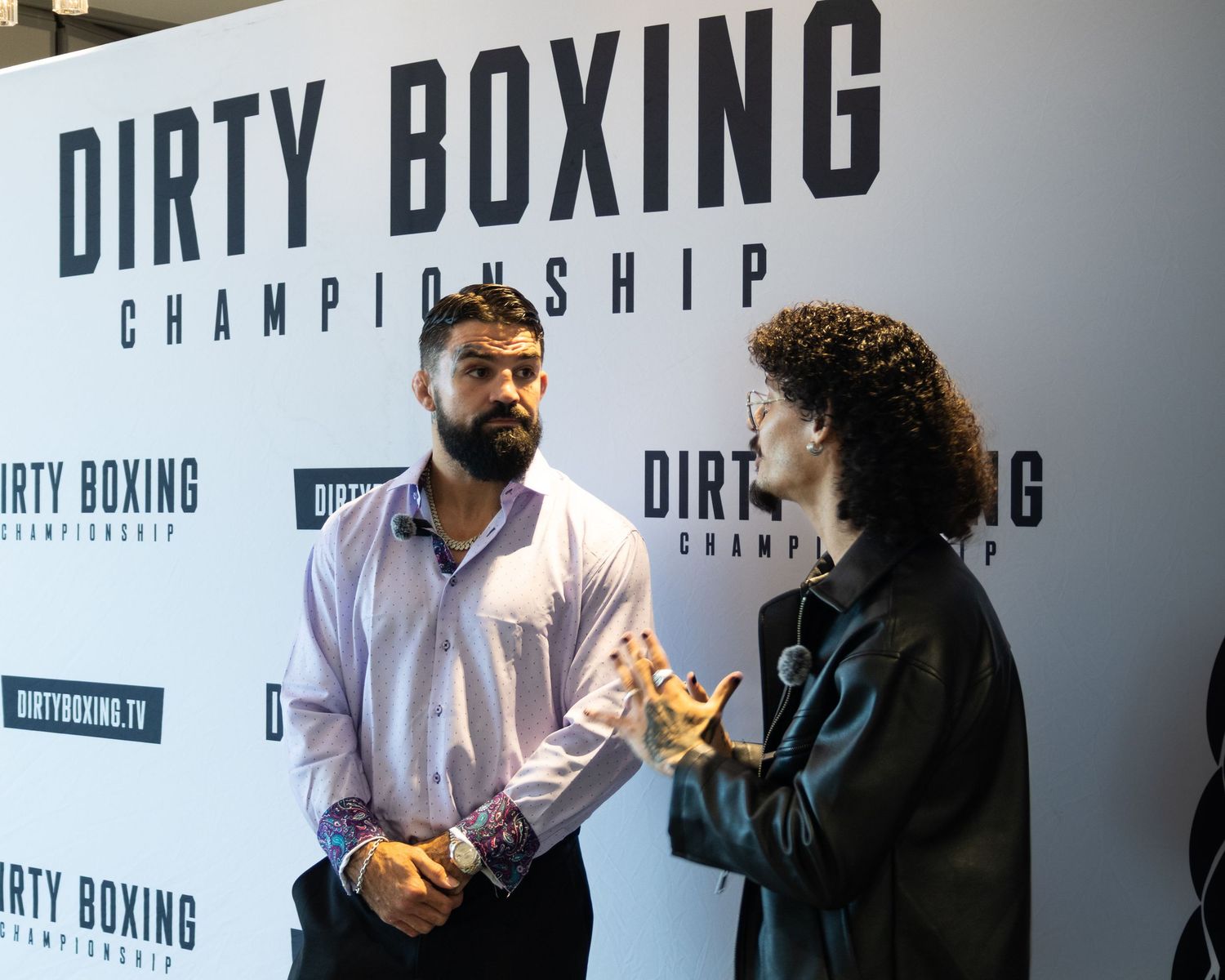 Interview setup with Dirty Boxing championship branding visible on backdrop.