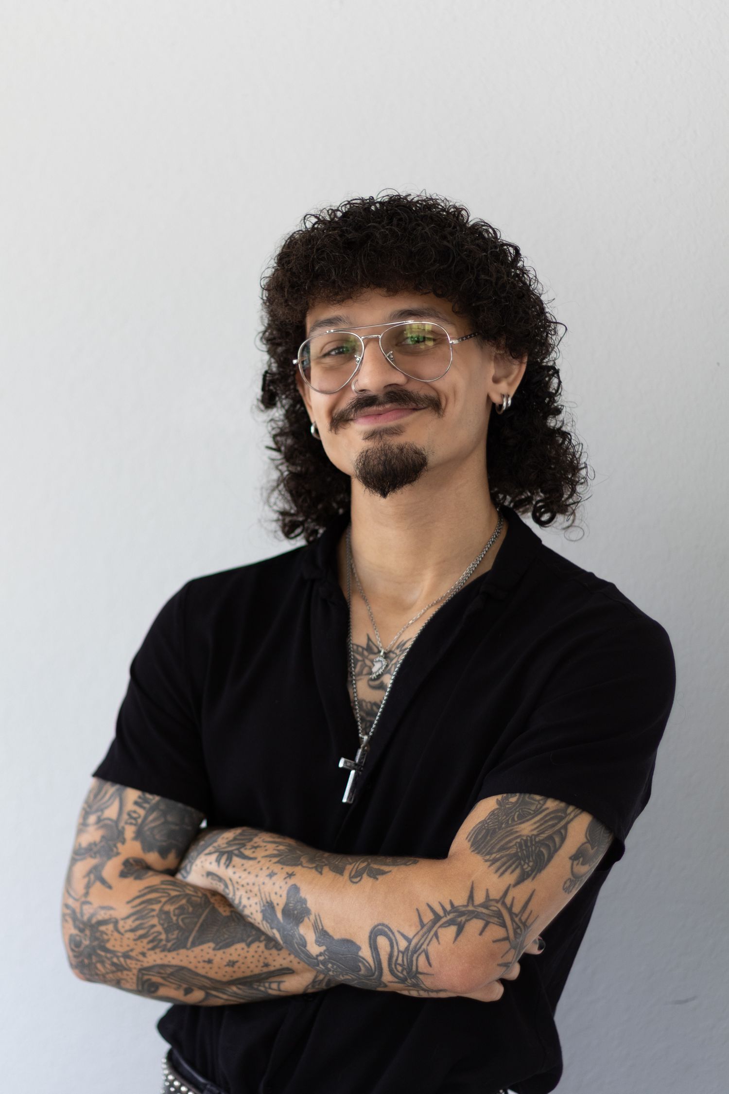Professional studio portraits showcasing tattoo art and casual poses in black attire.
Jonan Morales