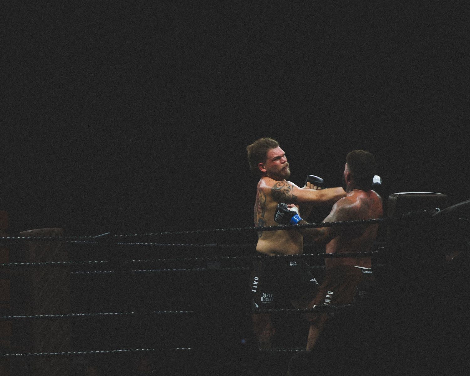 Two fighters engage in close combat with quick punches during a match.