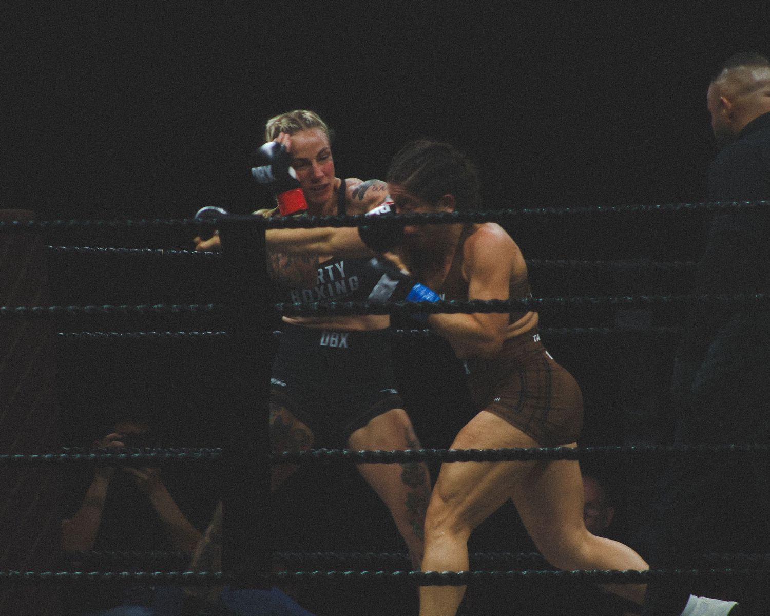 Boxers trade blows during close combat in a professional match.
