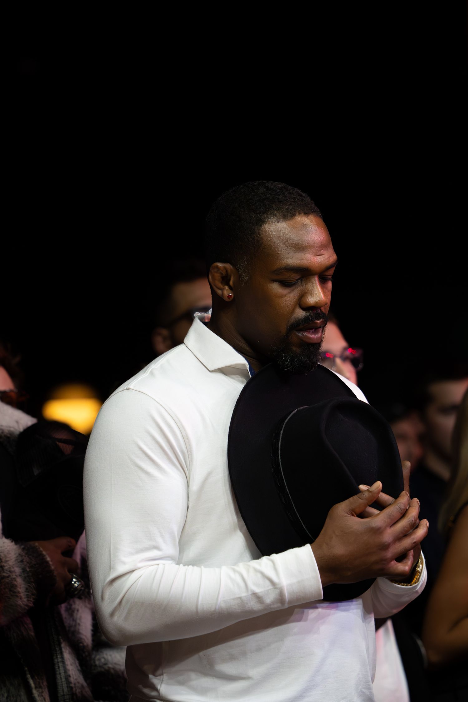 Two people embrace emotionally during a performance with one wearing white.
Jon Jones
