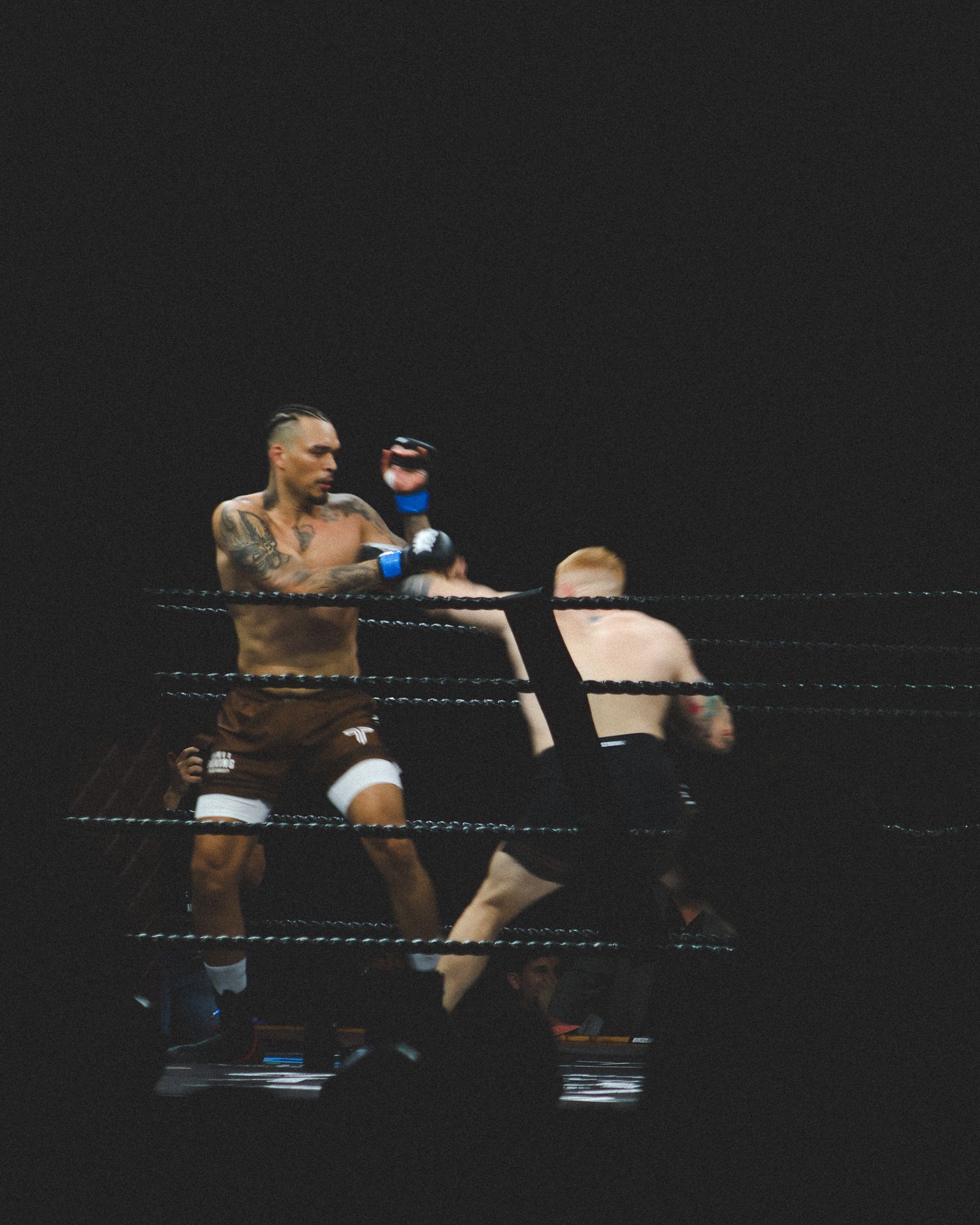 Boxers trade punches while maneuvering around the ring during their bout.