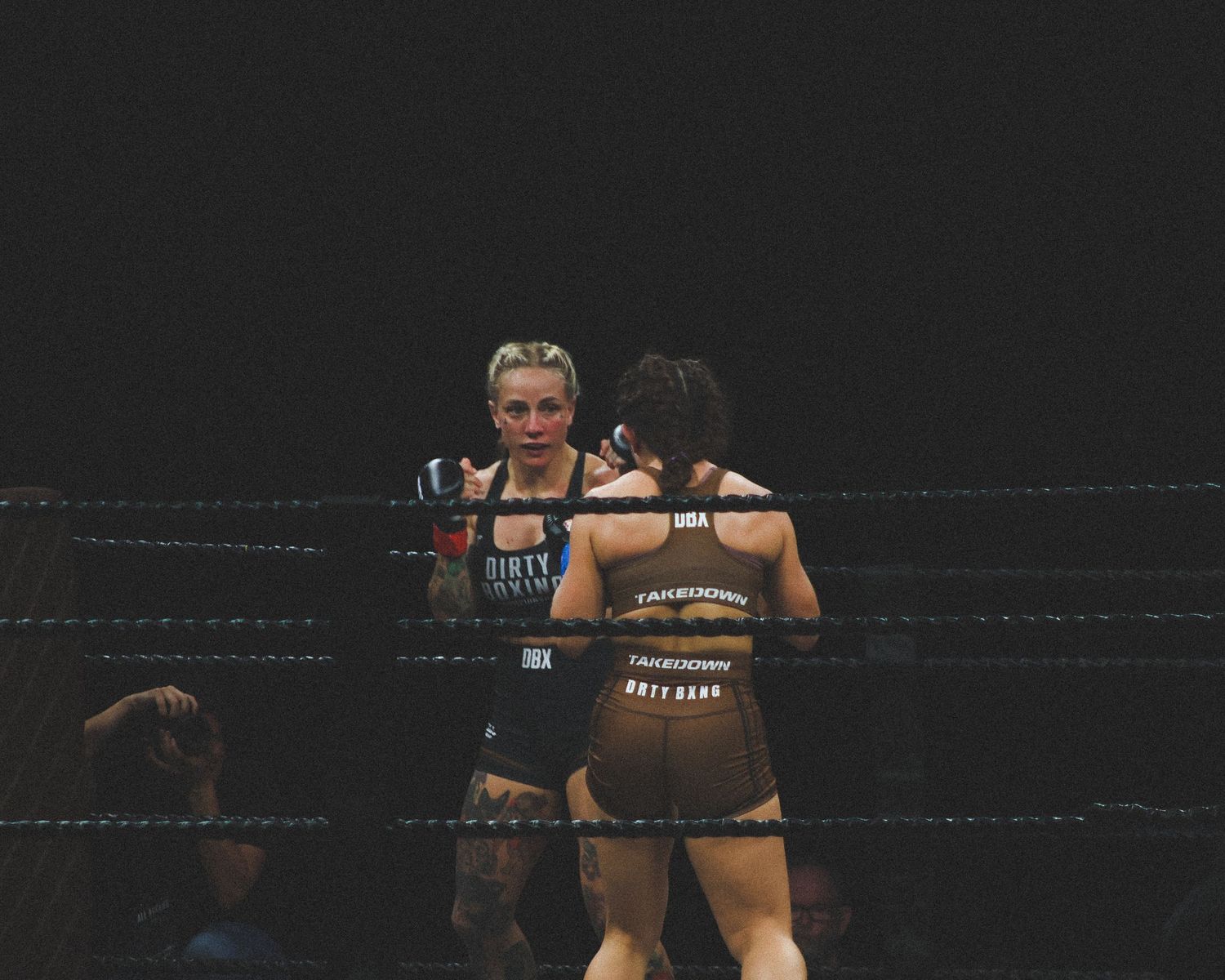 Two fighters locked in close combat during a professional boxing match.