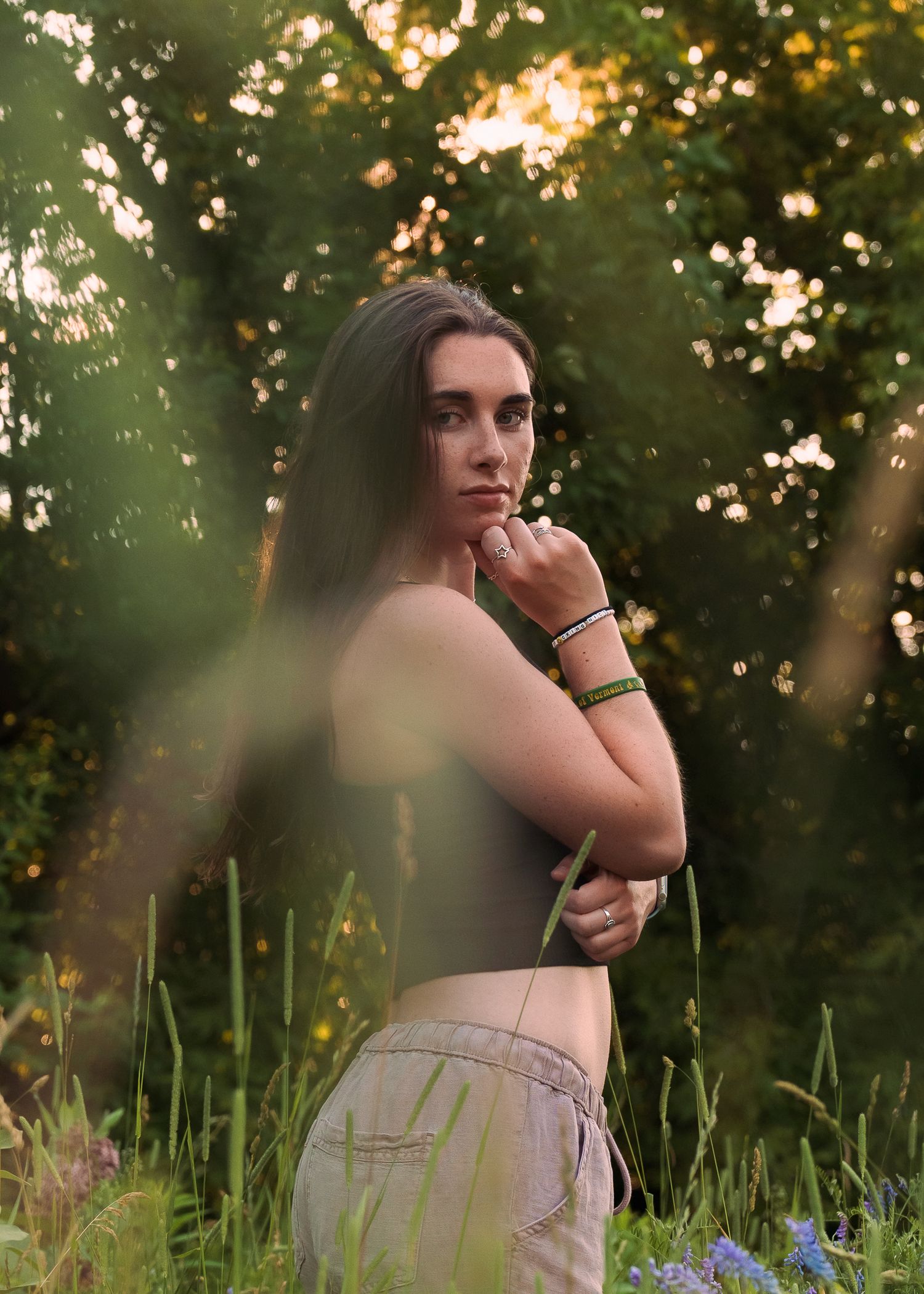 Artistic outdoor portrait in a forest setting during golden hour.