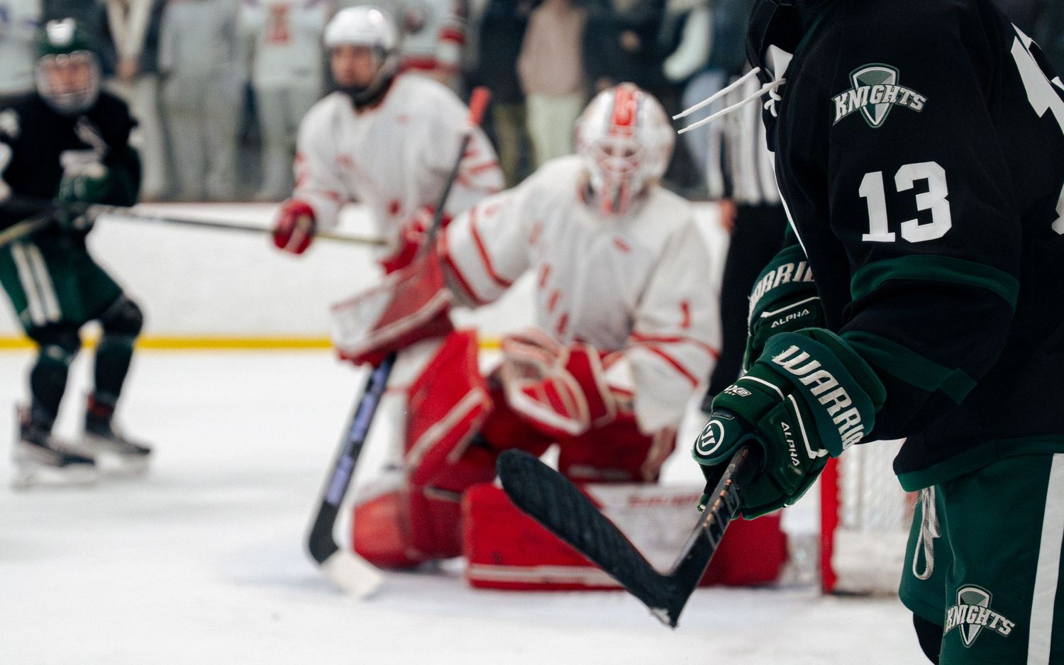 Hockey players from opposing teams battle for the puck during an intense game on the ice.