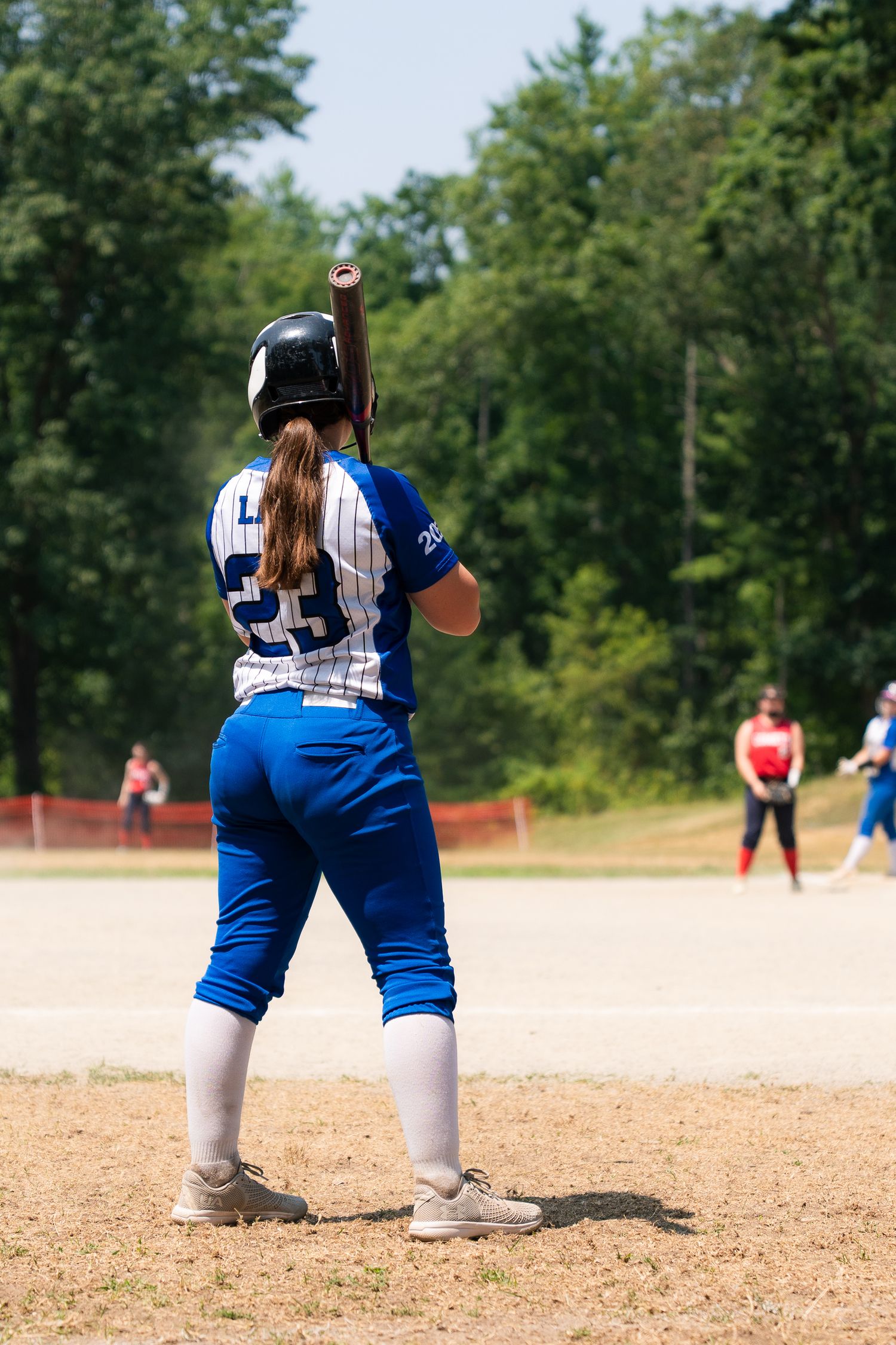 Close up views of softball players' stances and positions on a dirt field.