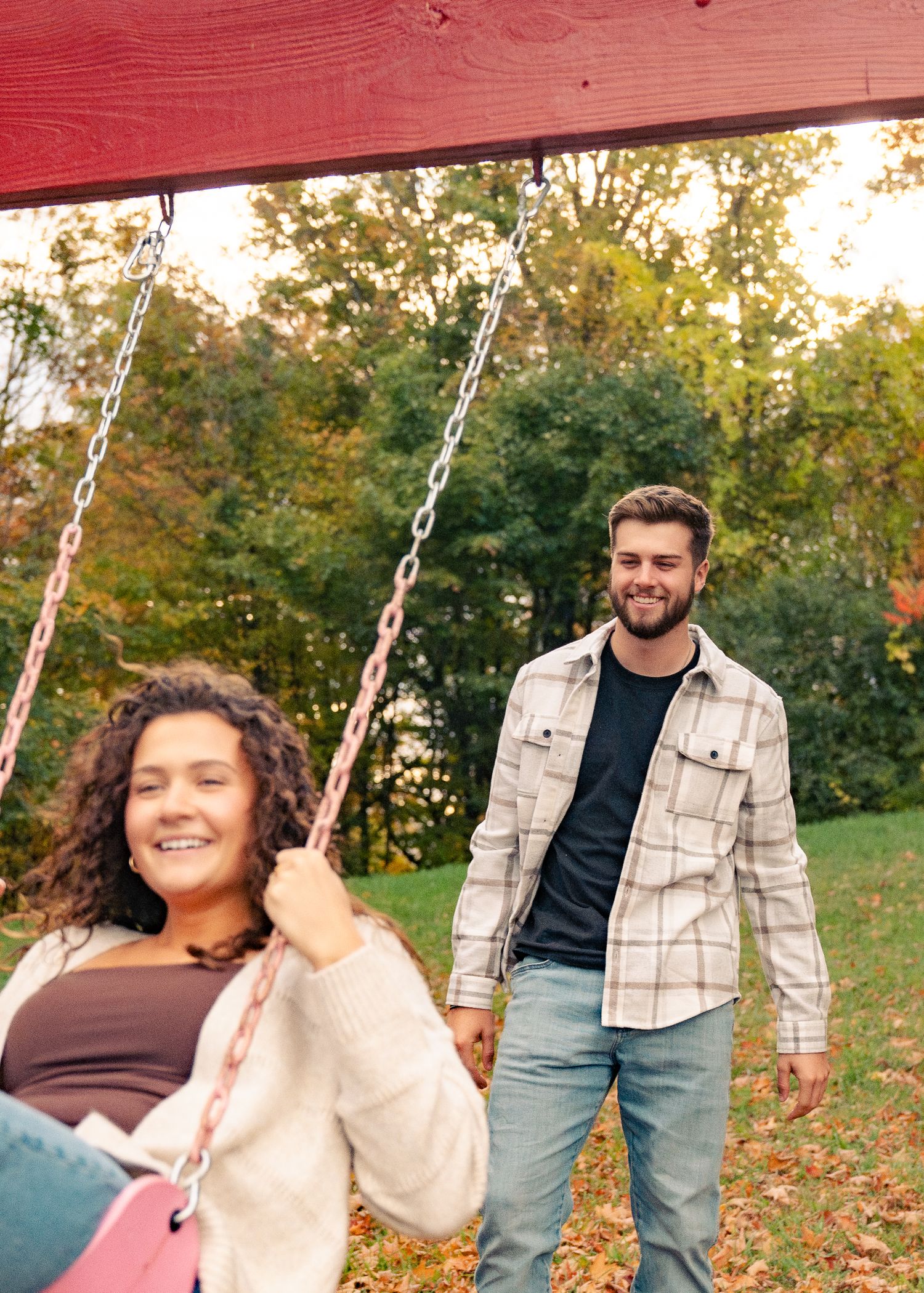 A sequence of autumn photos showing someone on a swing in a park with fallen leaves and trees in the background.