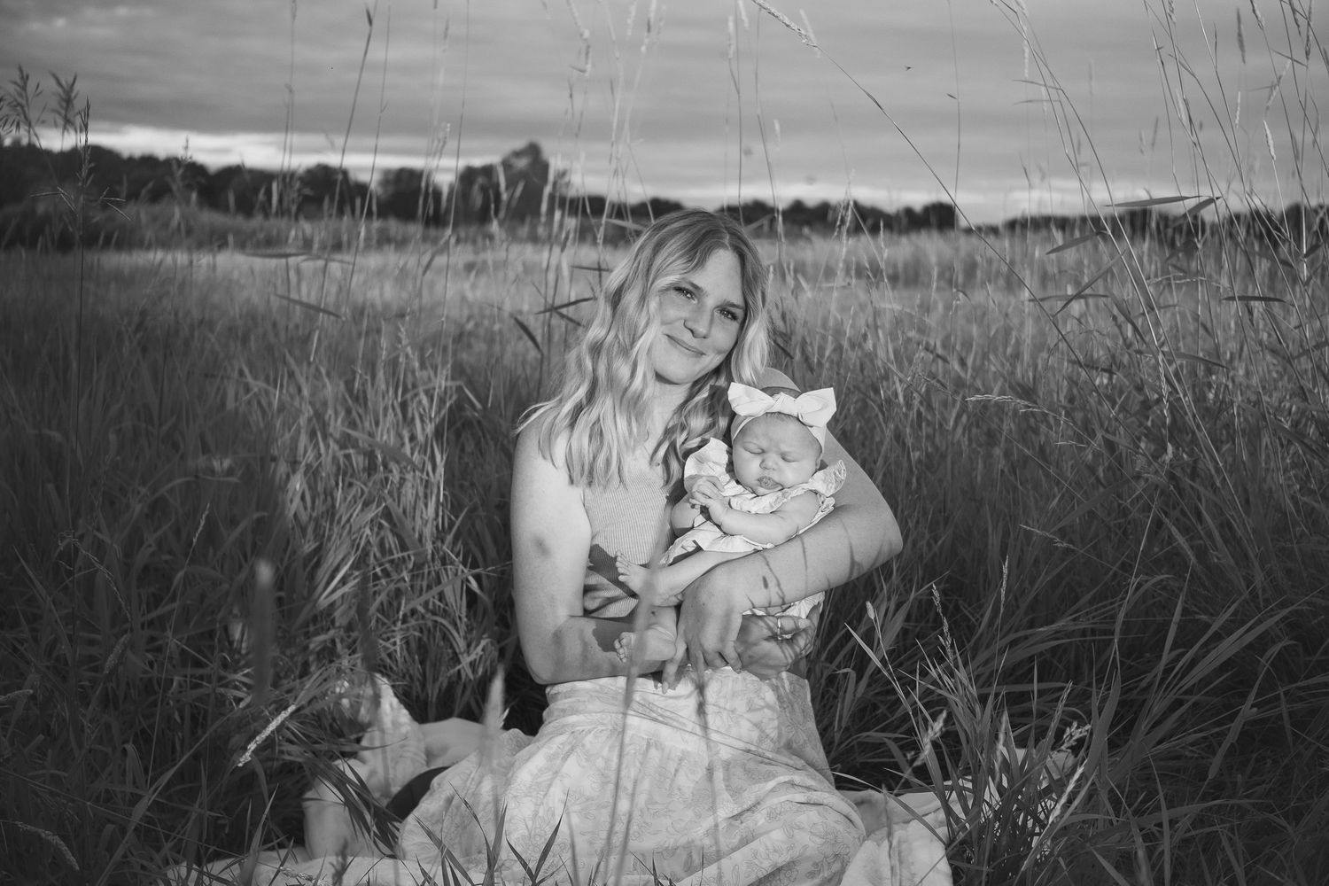 Black and white family portrait series in tall grass meadow.