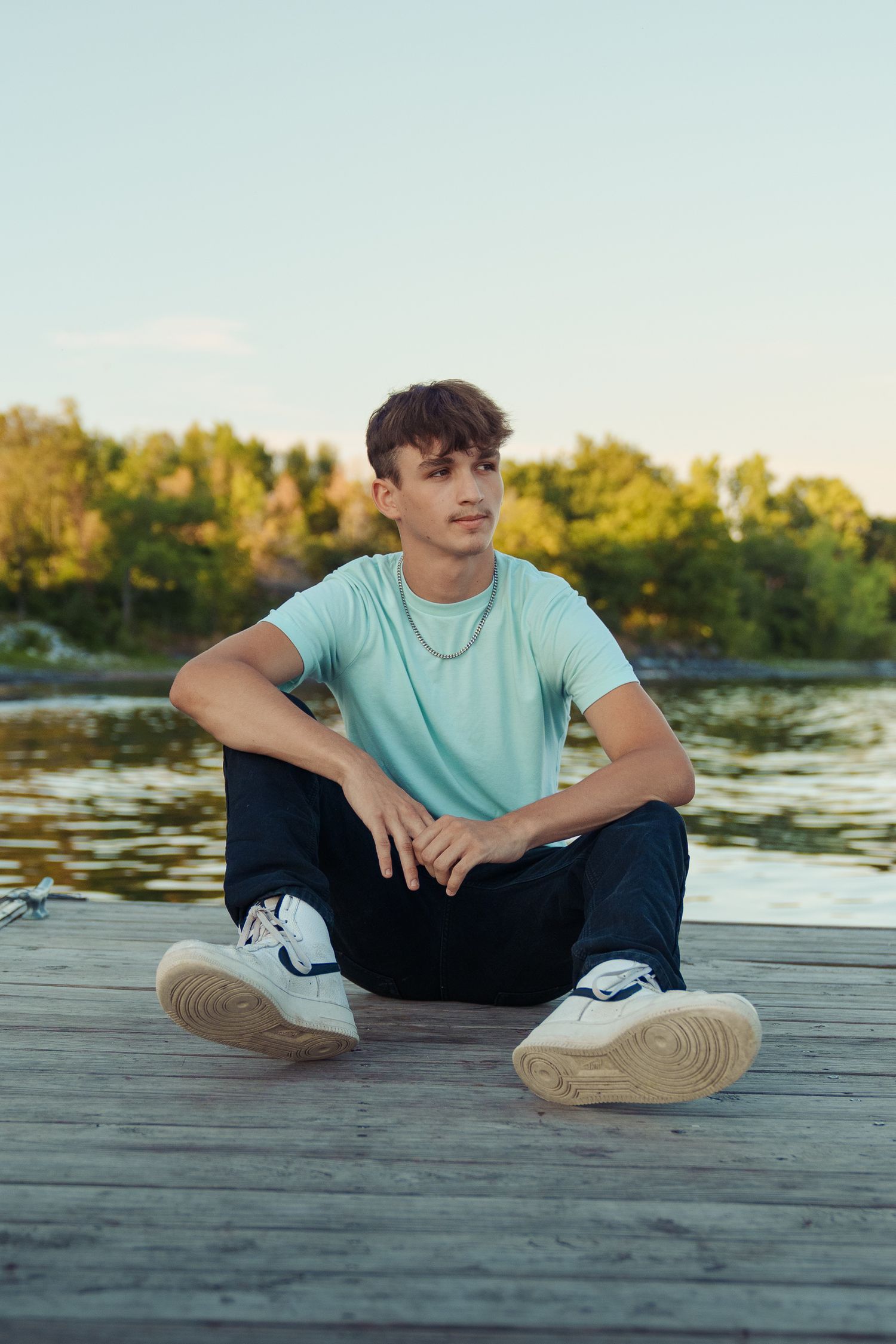 Casual portraits on a wooden dock by the water during golden hour.