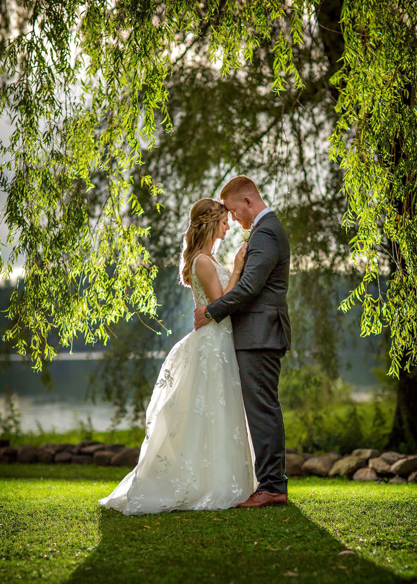Bride and groom backlit under tree at Old Daley on Crooked Lake house in Averill Park NY