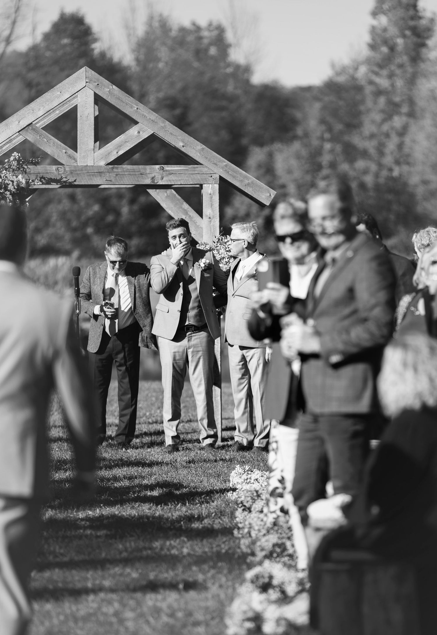 Groom getting emotional as bride walks down the aisle. Black and white. Taken by Sawicki Studios, Albany NY wedding photographers.