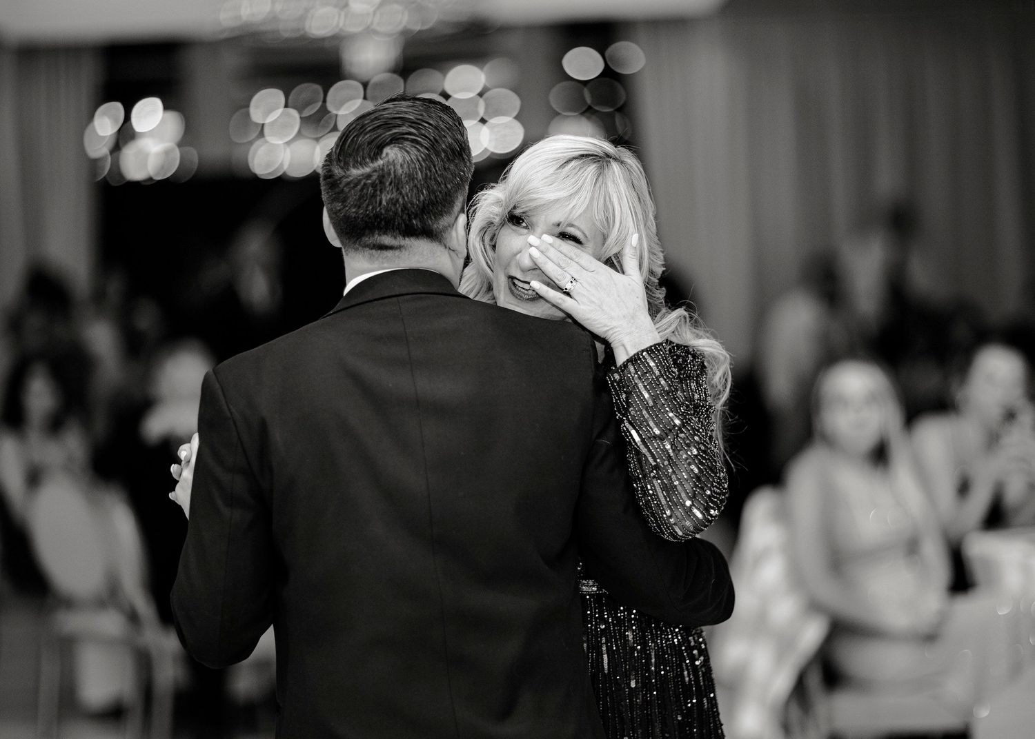 Mother wiping tears during mother son dance. Black and white photo. Adelphi Hotel wedding Saratoga Springs NY.