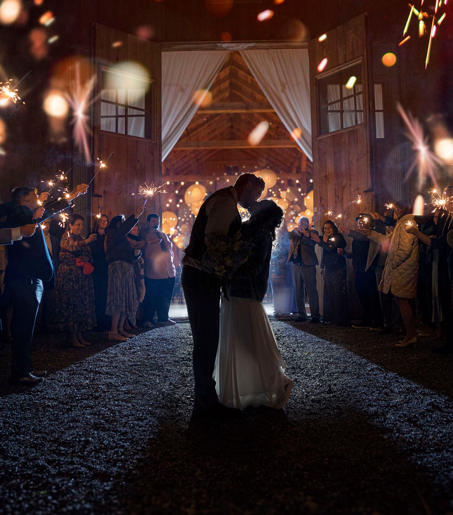 Bride and groom backlit with sparklers at Gables and Gardens wedding and event barn in Granville NY
