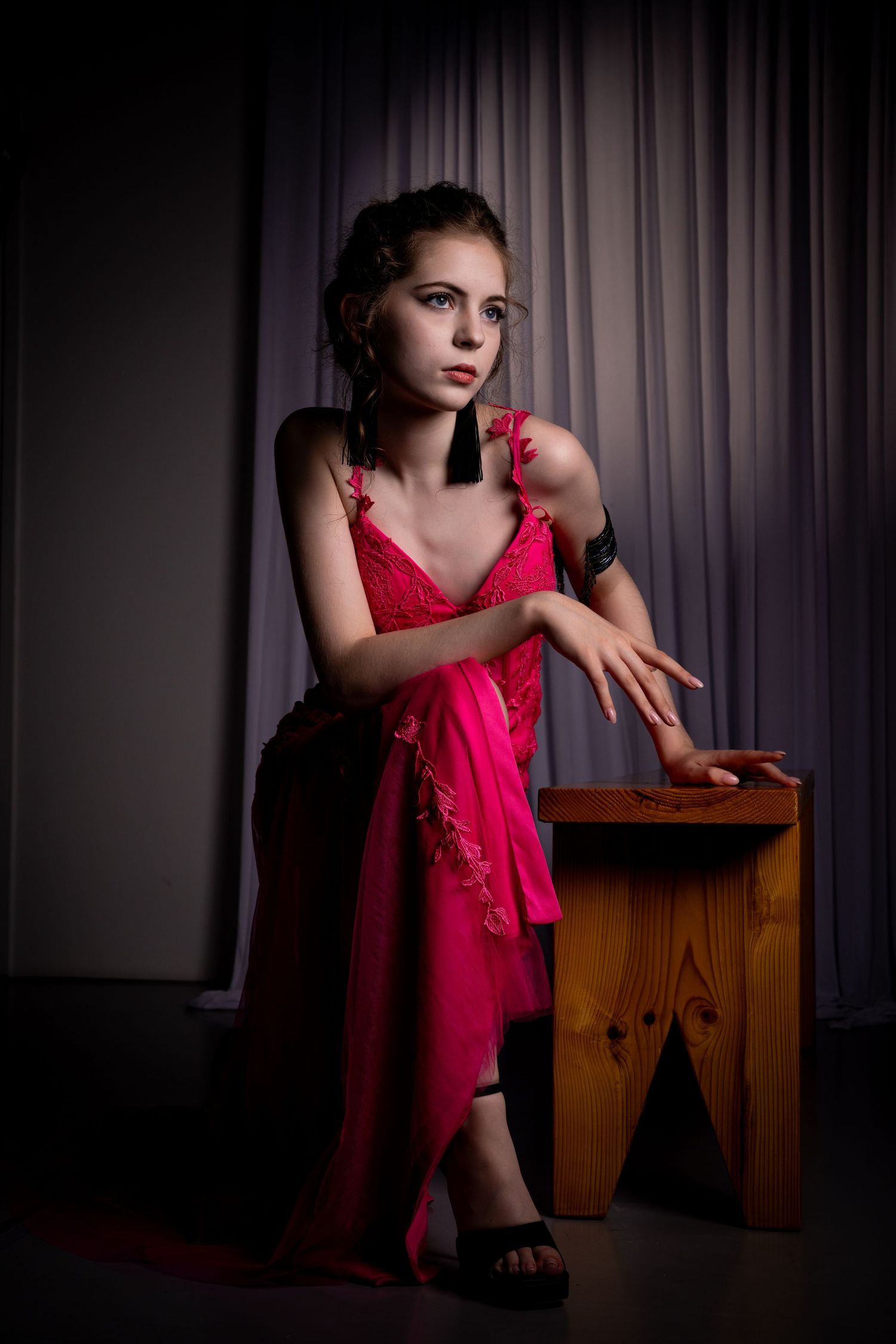 Expressive studio portraits featuring graceful poses with a wooden prop and pink dress.