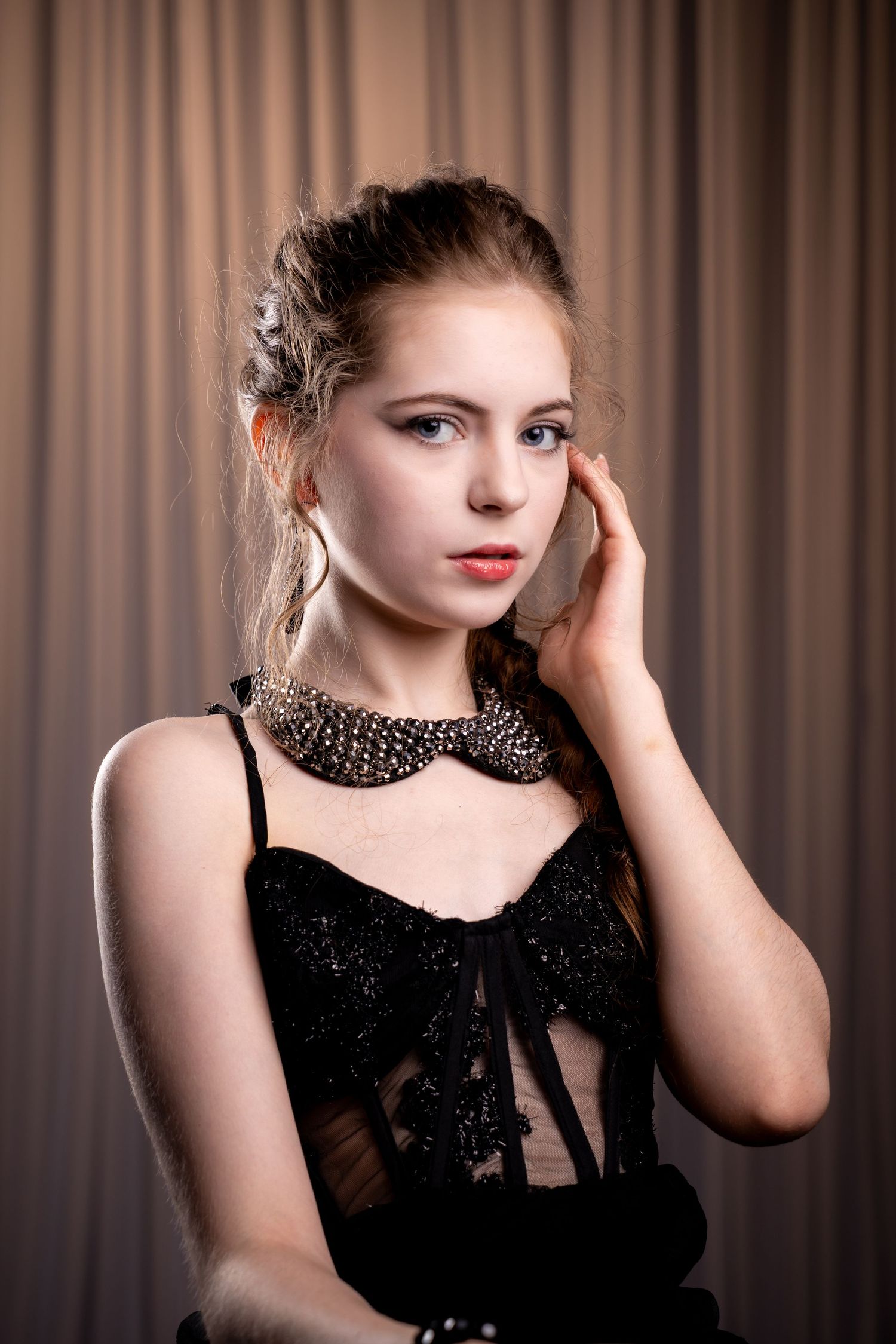 Portrait series in black formal attire against brown curtain backdrop.