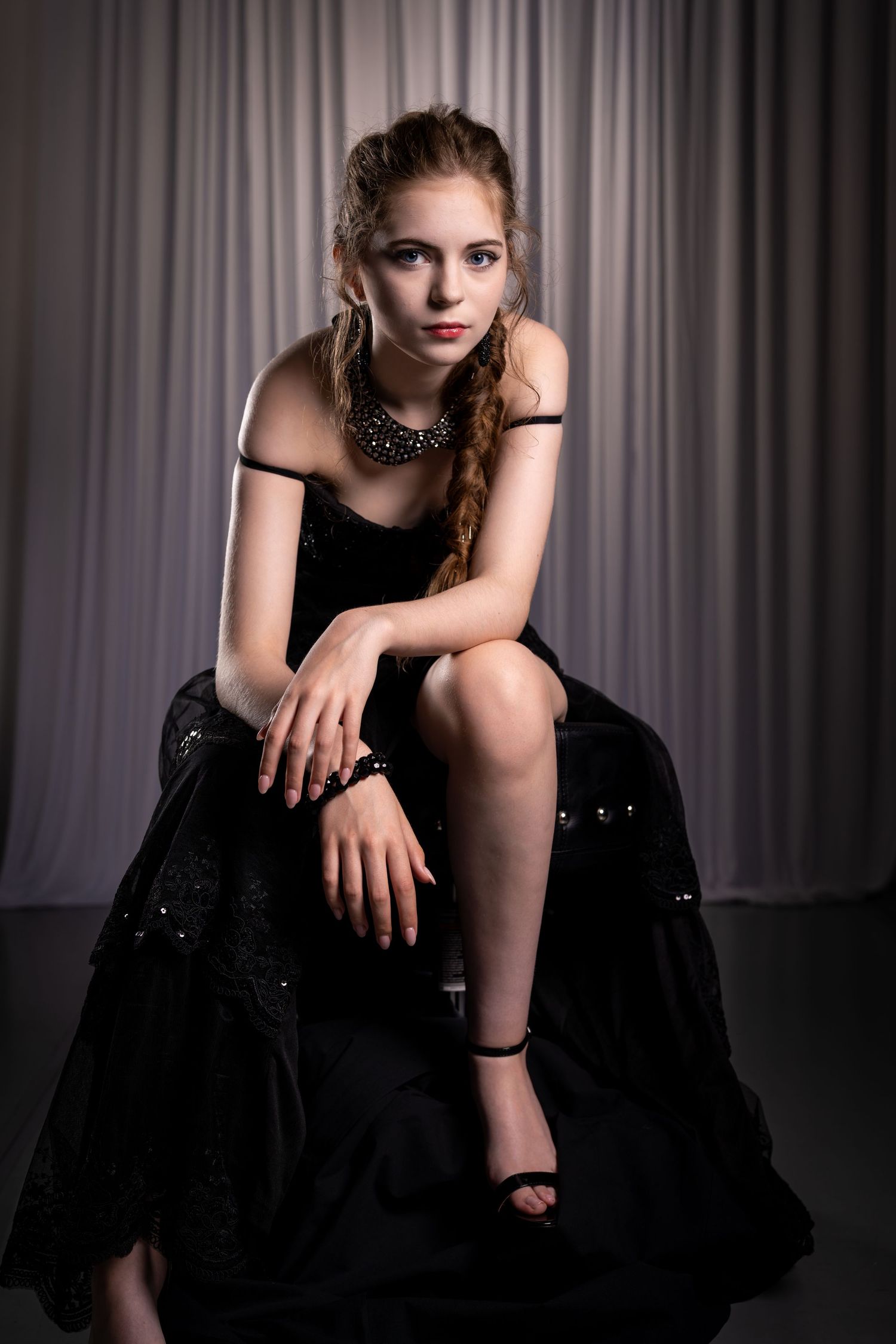Artistic portrait series showing elegant poses in a black dress with dramatic studio lighting.