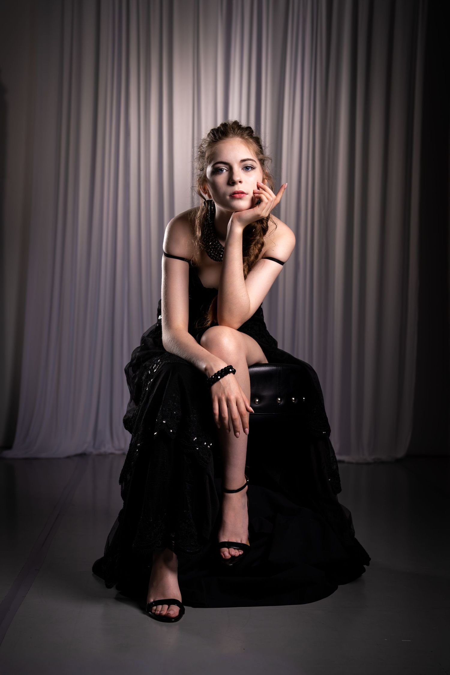 Artistic studio portraits with dramatic lighting showcasing elegant poses in formal attire.