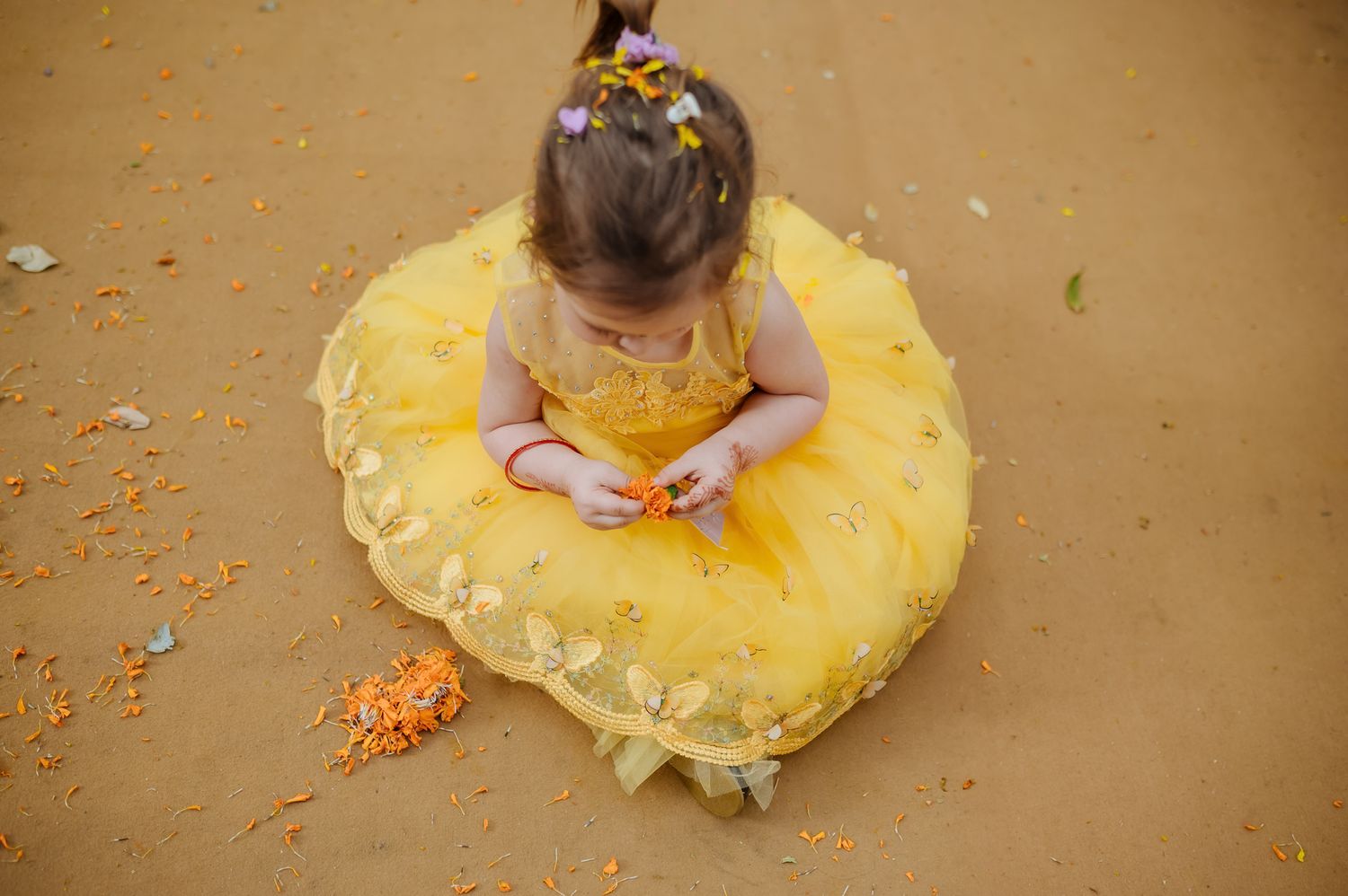 Kids covered in turmeric during an Indo-Norwegian wedding and playing with flowers during a joyful Haldi wedding ritual