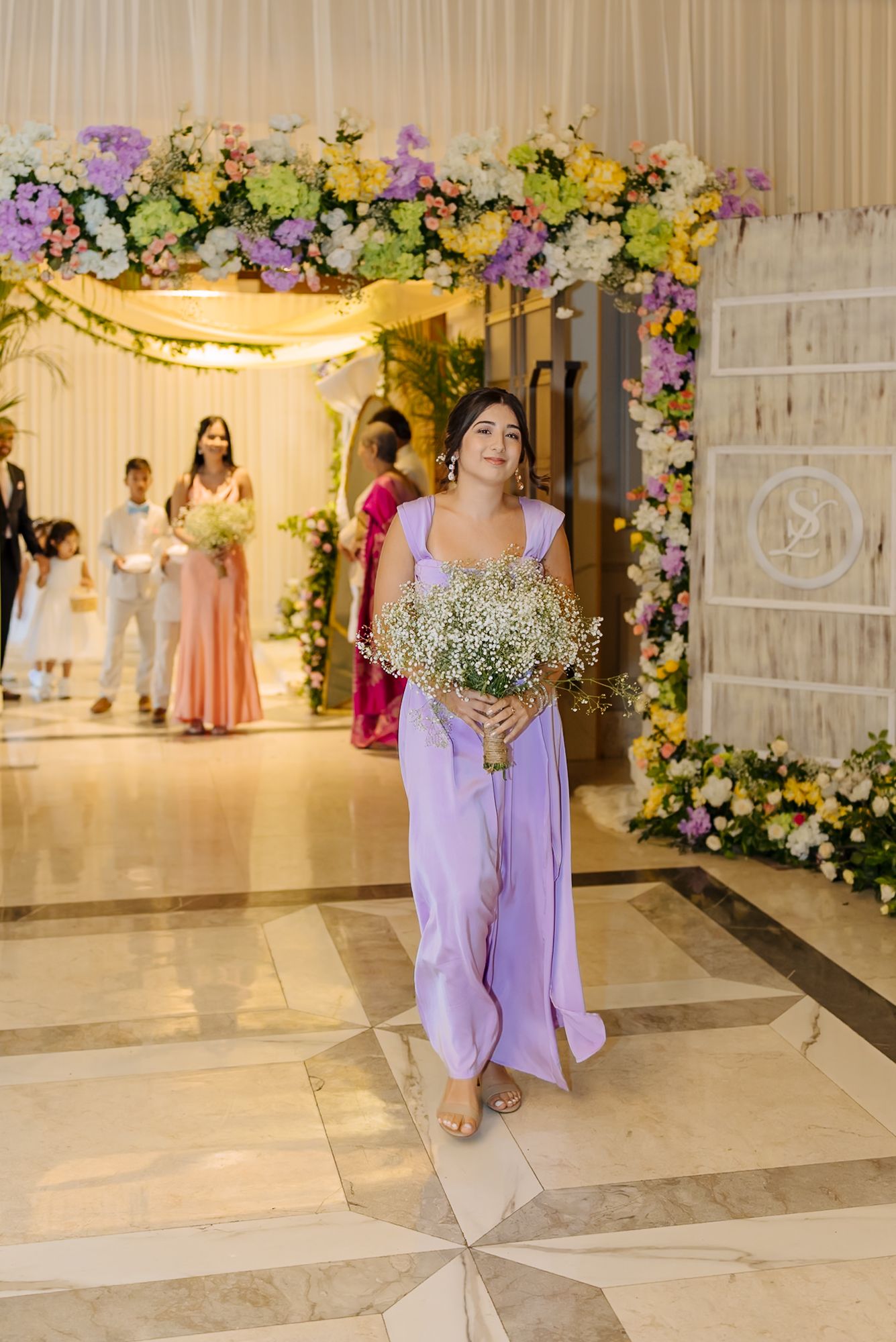 Bridesmaids walking down the aisle during Shorye and Leah's Christian wedding ceremony at Tivoli Chattarpur