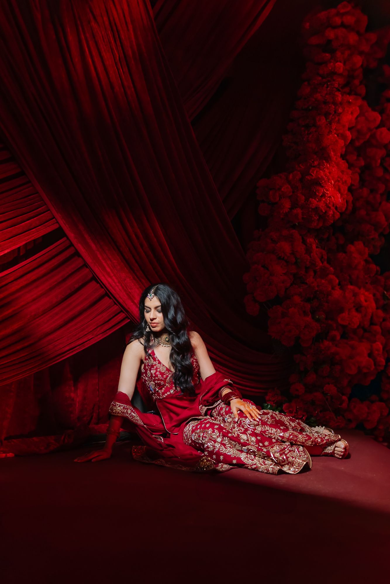 Bride and groom Shorye and Leah dressed in black and red for their Indian wedding Sangeet at Tivoli Chattarpur