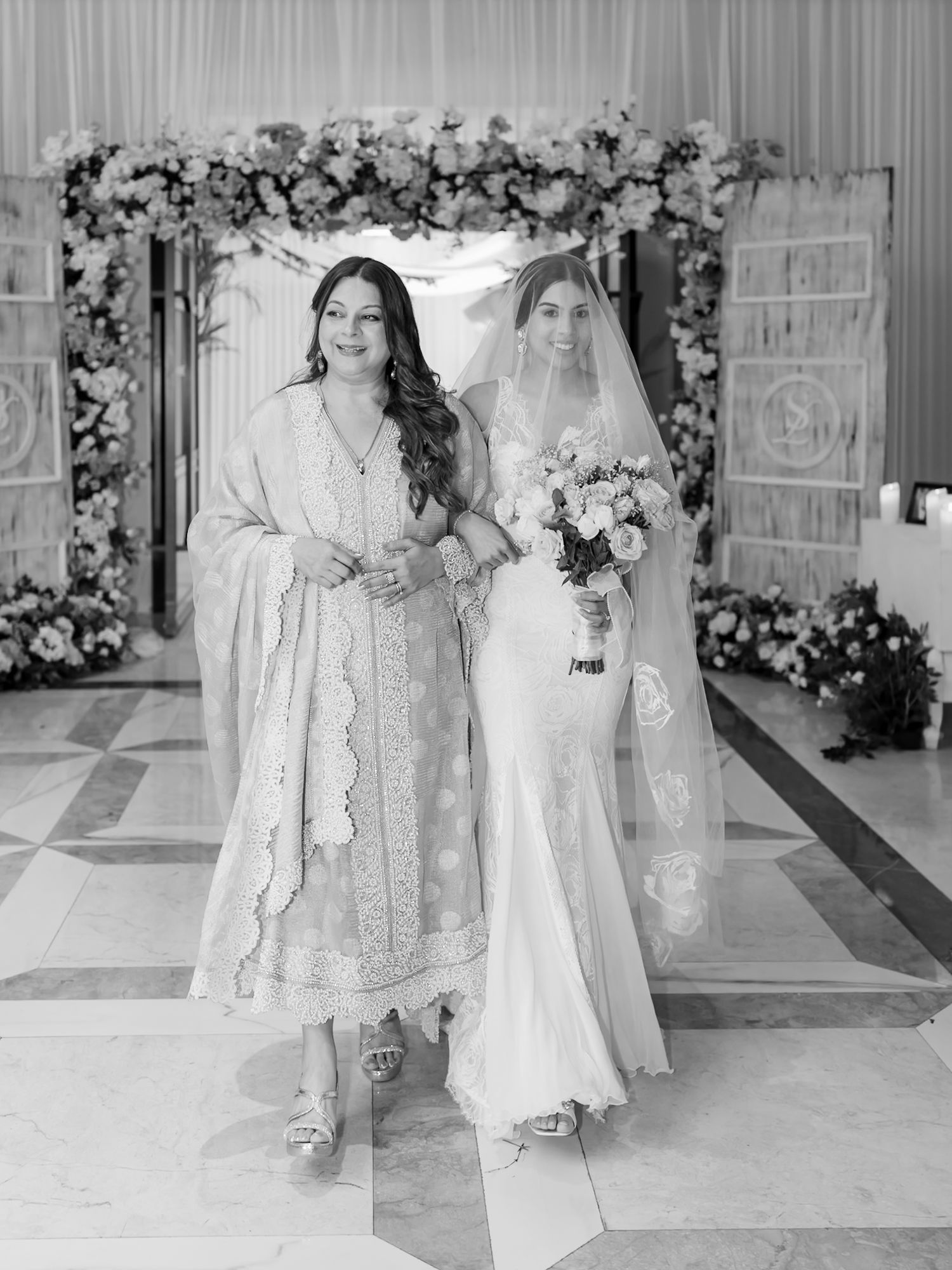 Leah walking down the aisle with her mother during her Christian wedding ceremony at Tivoli Chattarpur