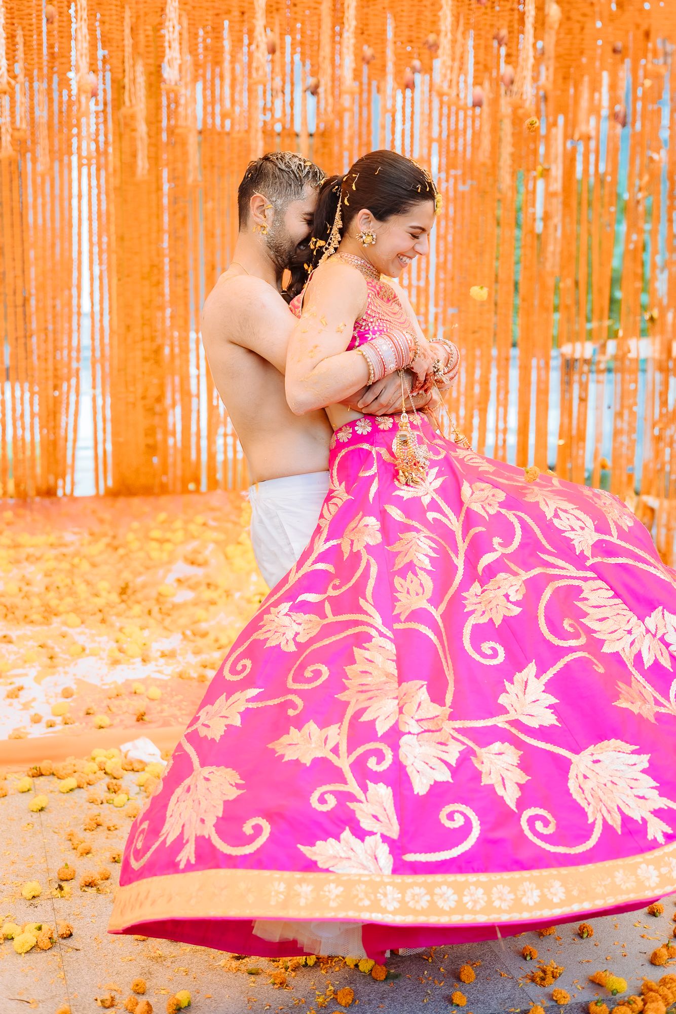 Colourful flower petals raining over Shorye and Leah during the Haldi at Tivoli Chattarpur