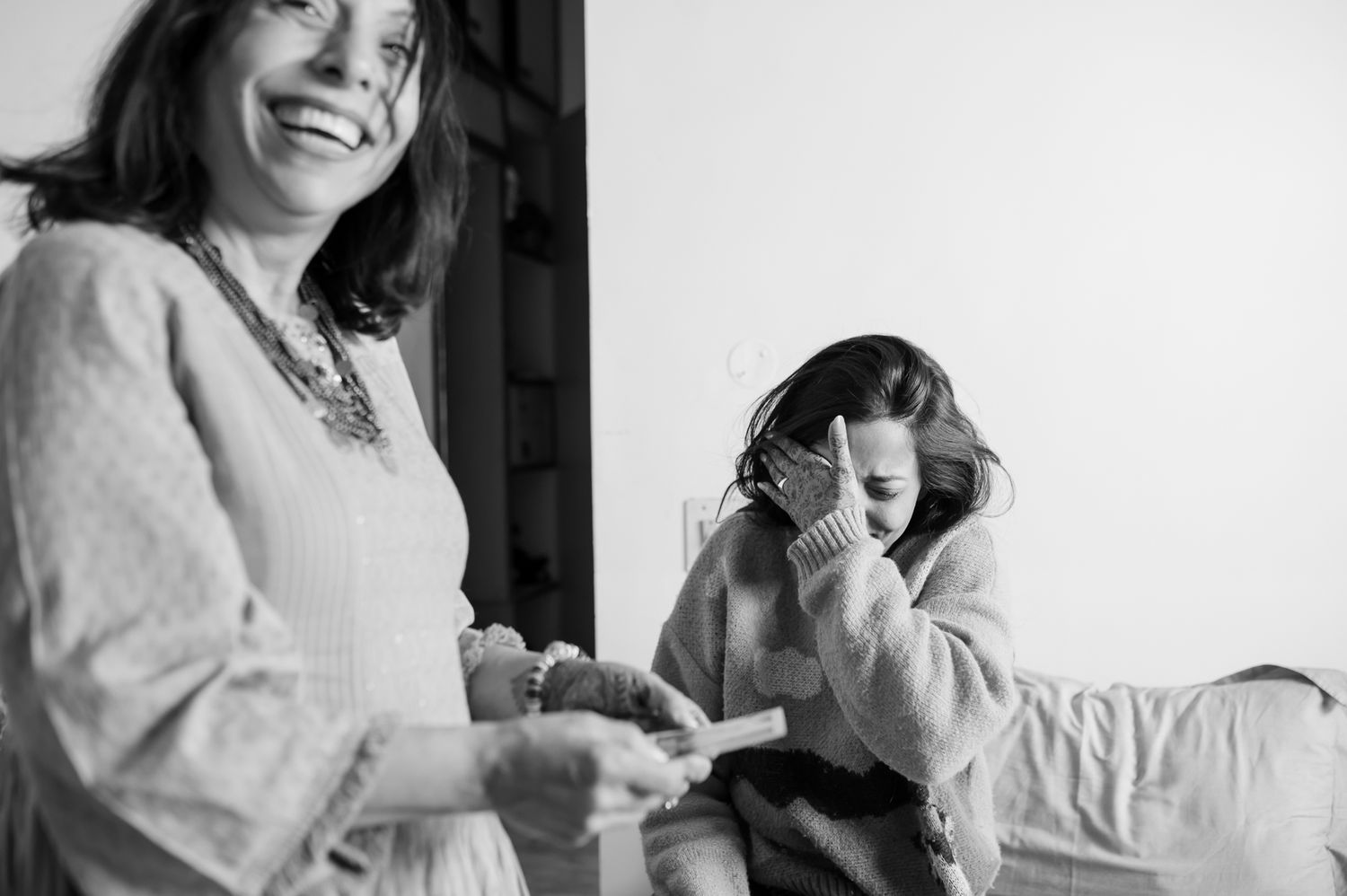 Emotional mother-daughter moment with vintage family photographs on the wedding morning by Storytelling wedding photography
