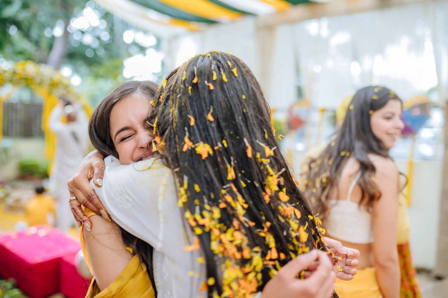 Bride and groom covered in turmeric during an Indo-Norwegian wedding and Family applying Haldi to the bride during a joyful wedding ritual