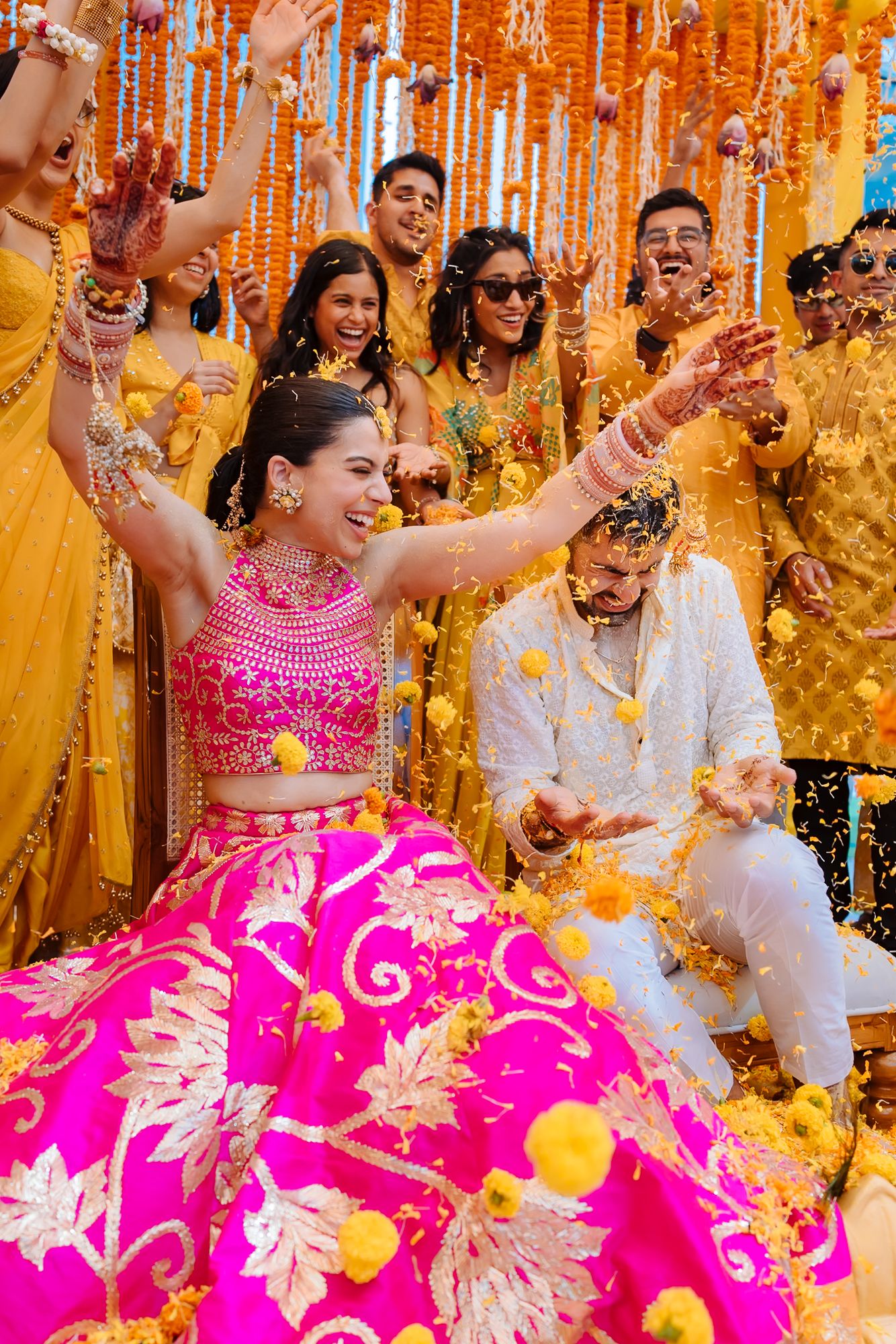 Colourful flower petals raining over Shorye and Leah during the Haldi at Tivoli Chattarpur